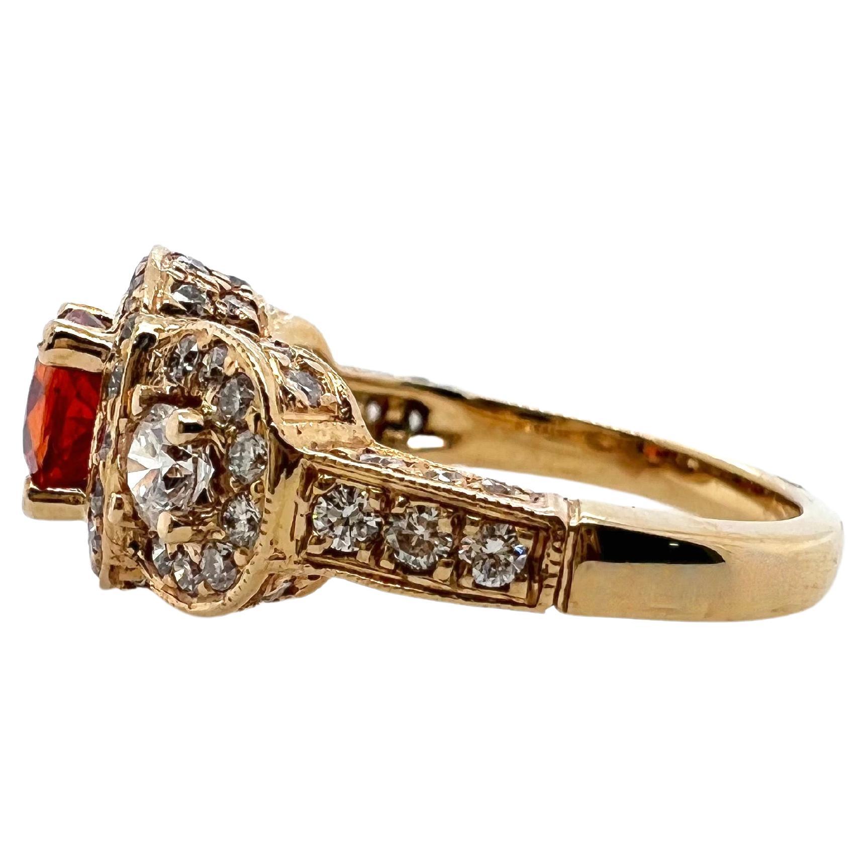  This stunning 3-stone style halo ring with a vibrant orange sapphire will grasp everyone's attention.  The mounting is set with brilliant round diamonds around the top and profile.  The warm orange hue against the yellow gold is soft and easy to