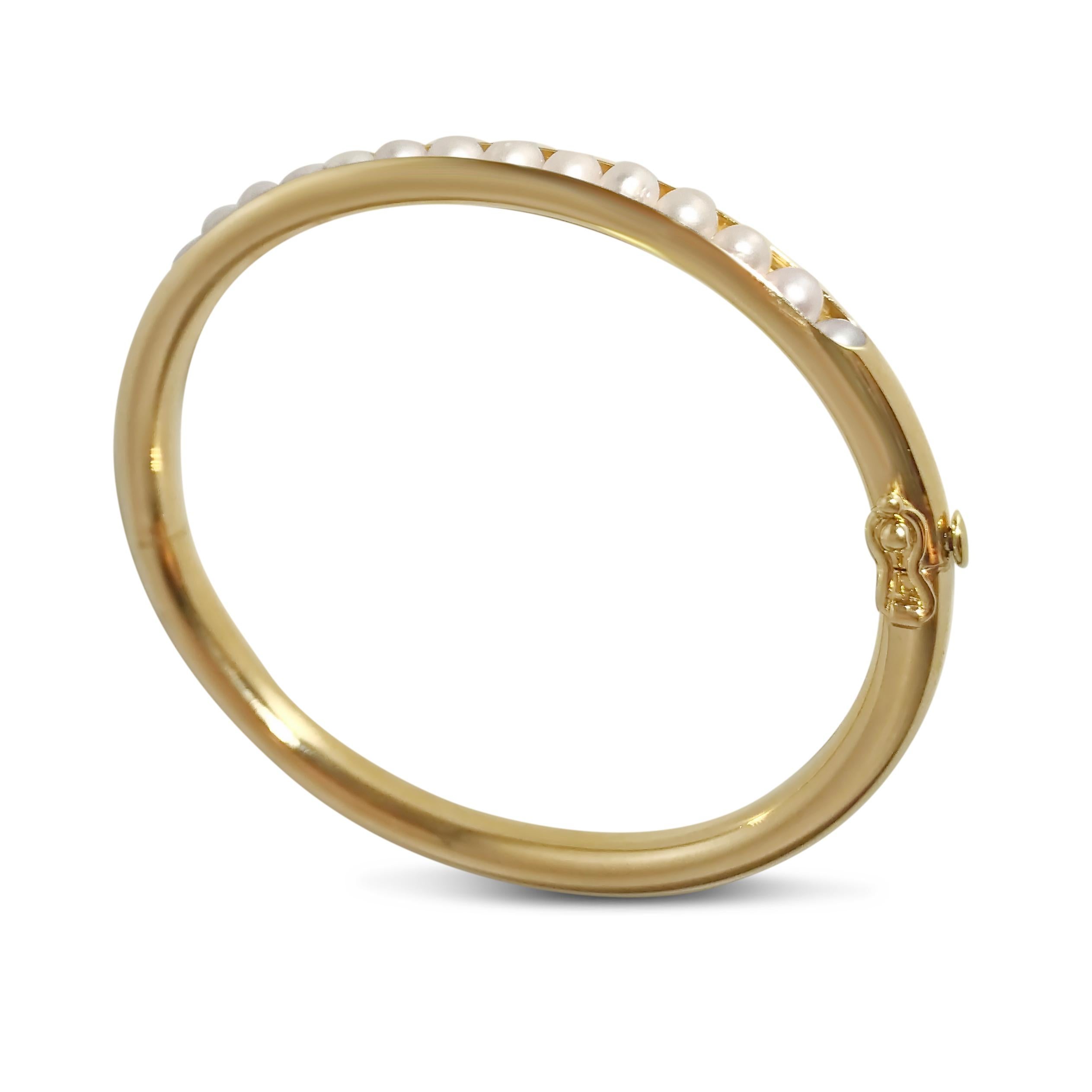 Modern meets classic with our gold bangle with inlayed semi-precious pearls. Our ‘T-Pearl’ 14K yellow gold oval-shaped bracelet is 3/16 inch in width and securely closes with a snap & hinge.

Specifications:
- Stone(s): Pearls
- Shape: Oval
-