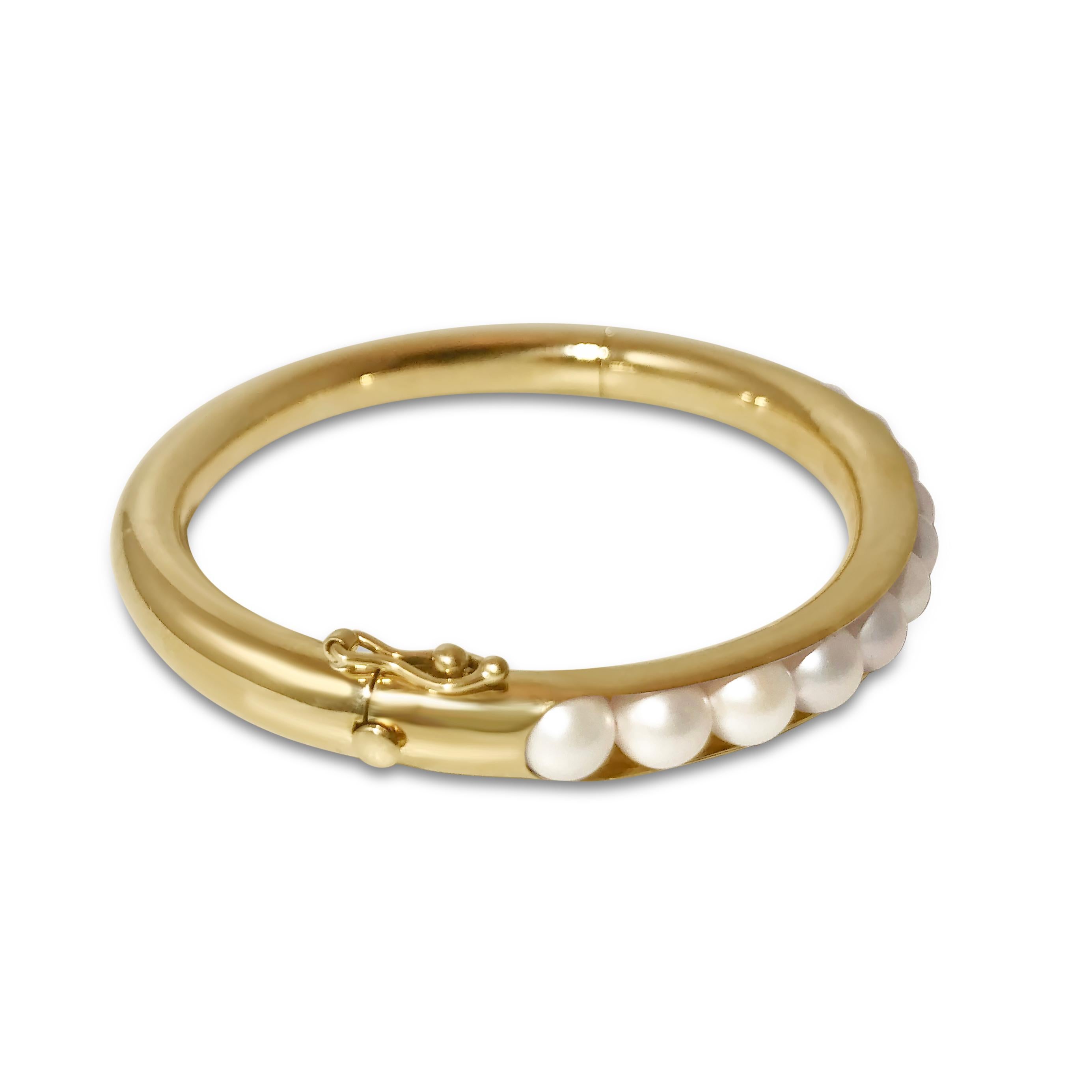 Modern meets classic with our gold bangle with inlayed semi-precious pearls. Our ‘T-Pearl’ 14K yellow gold oval-shaped bracelet is ¼ inch in width and securely closes with a snap & hinge.

Specifications:
- Stone(s): Pearl
- Shape: Oval
- Dimension: