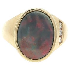 Anello con castone ovale in oro giallo 14k con opale Boulder infuocato e diamante