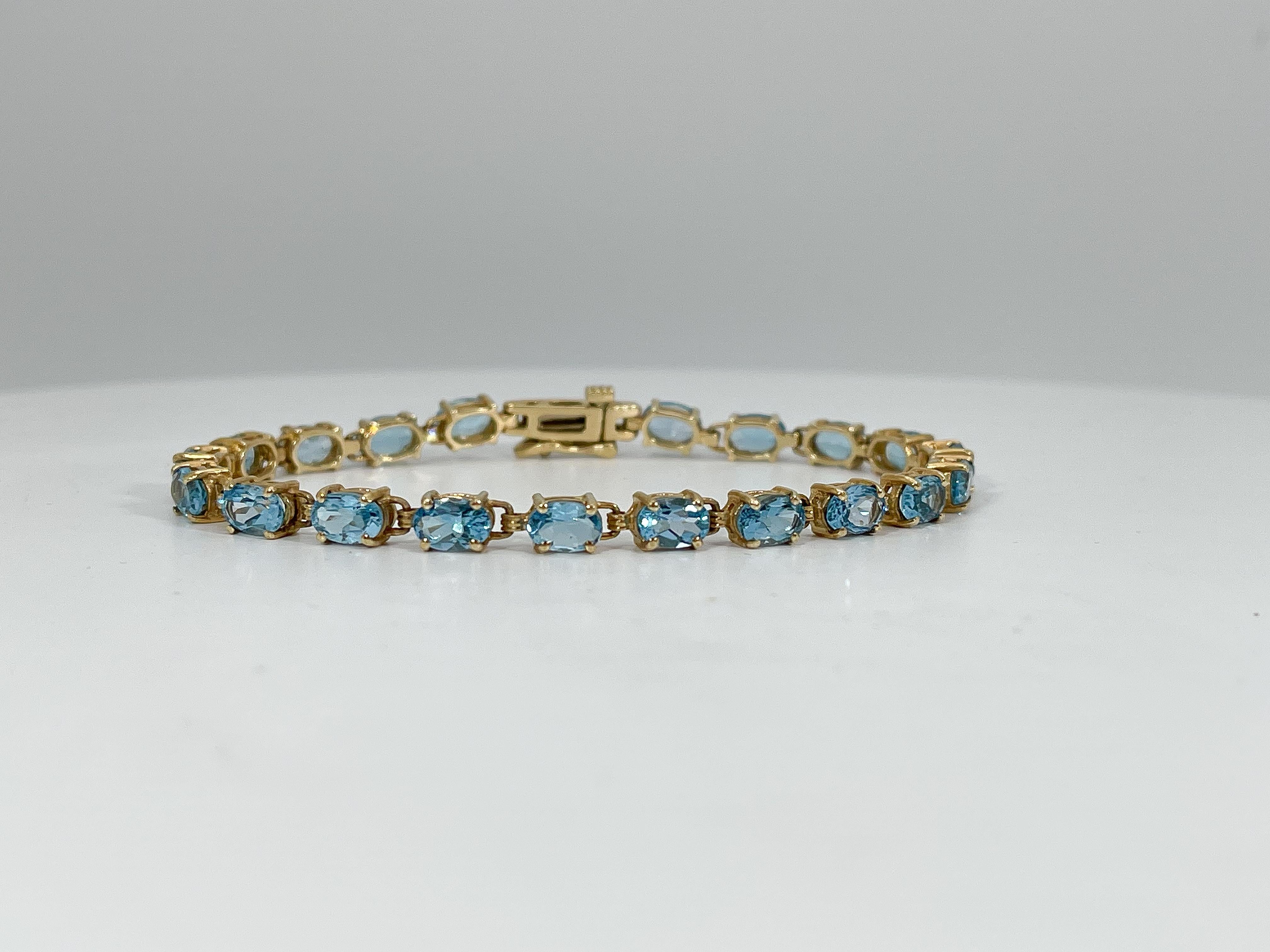 14k yellow gold oval blue topaz bracelet. This bracelet has 20 stones, a figure 8 clasp to open and close, the width of the bracelet is  4 mm, has a length of 7 inches, and a total weight of 10.18 grams.