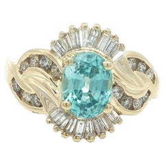 Anello floreale intrecciato in oro giallo 14k con topazio blu ovale e diamanti