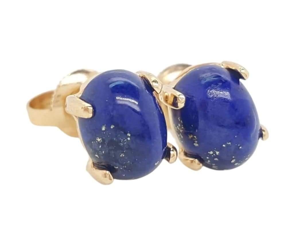 14 Karat Yellow Gold Oval Cabochon Lapis Lazuli Stud Earrings.  The earrings feature a pair of oval cabochon stunning blue lapis lazuli.  The lapis are each set into a 14 karat yellow gold four prong setting, completed by posts and friction backs. 