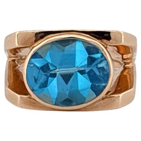 Questo sorprendente anello in oro giallo 14k mette in mostra l'affascinante bellezza di un topazio blu svizzero in un design elegante e contemporaneo. Al centro si trova un topazio ovale, famoso per la sua tonalità blu cristallina che irradia