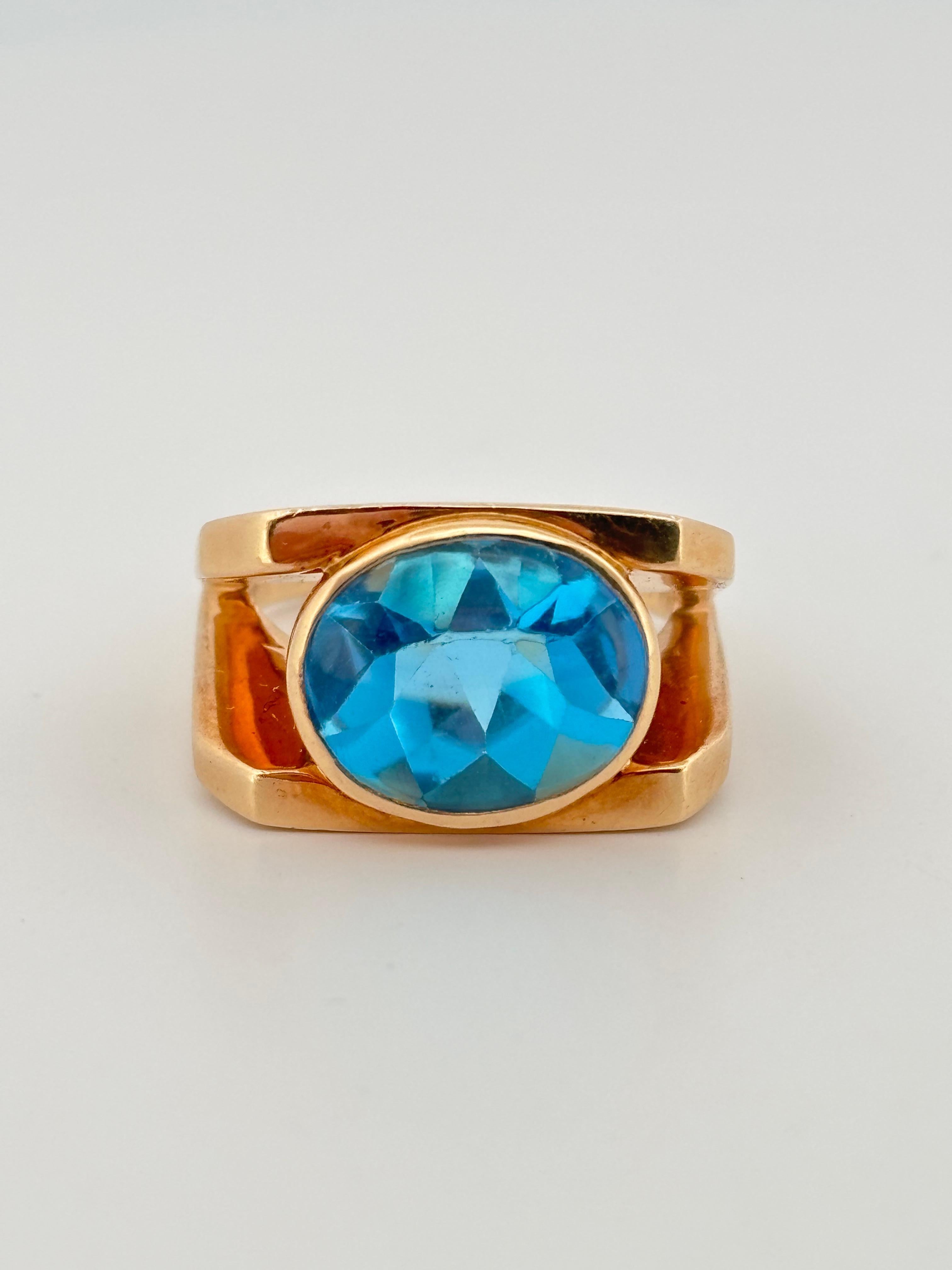Cette remarquable bague en or jaune 14k met en valeur la beauté captivante d'une topaze bleue suisse dans un design élégant et contemporain. En son centre repose une topaze de taille ovale, célèbre pour sa teinte bleue vive et cristalline qui