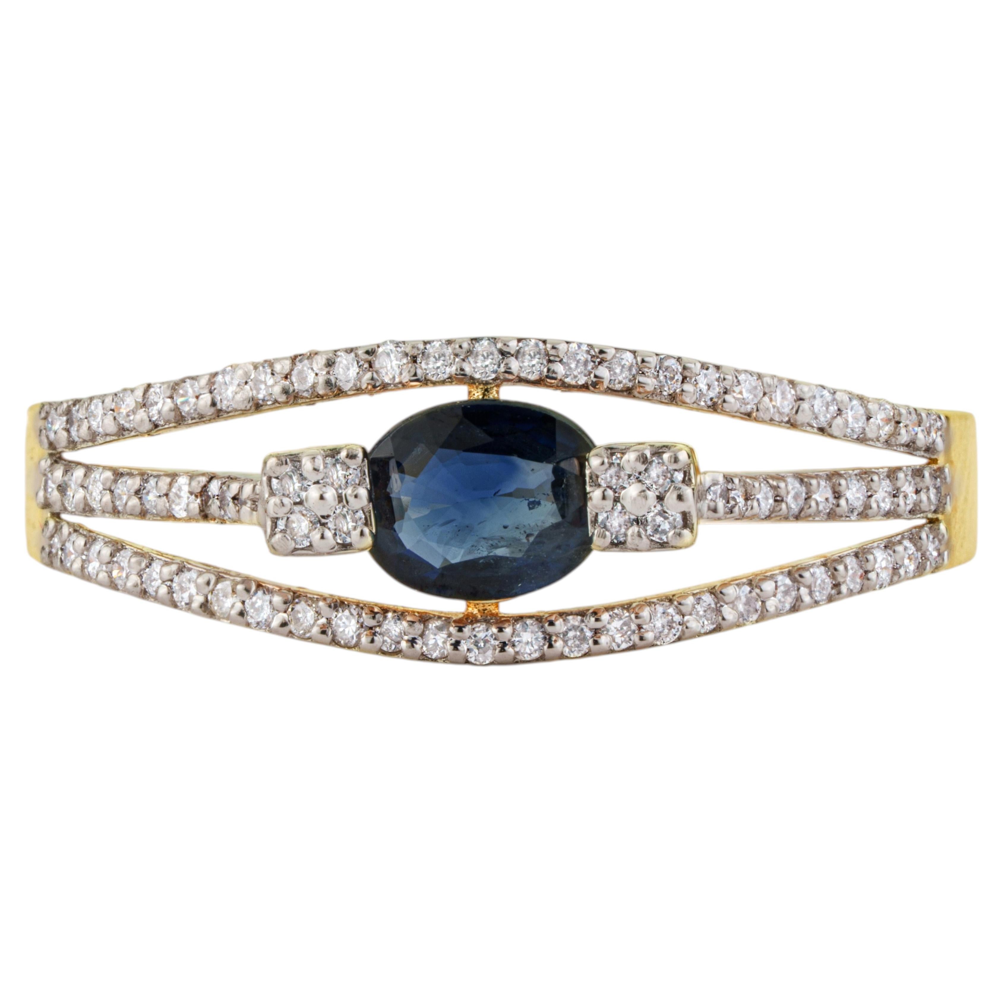 Ring aus 14-karätigem Gelbgold mit blauem Saphir im Ovalschliff und Diamanten, geteilter Ringband, modernes Design