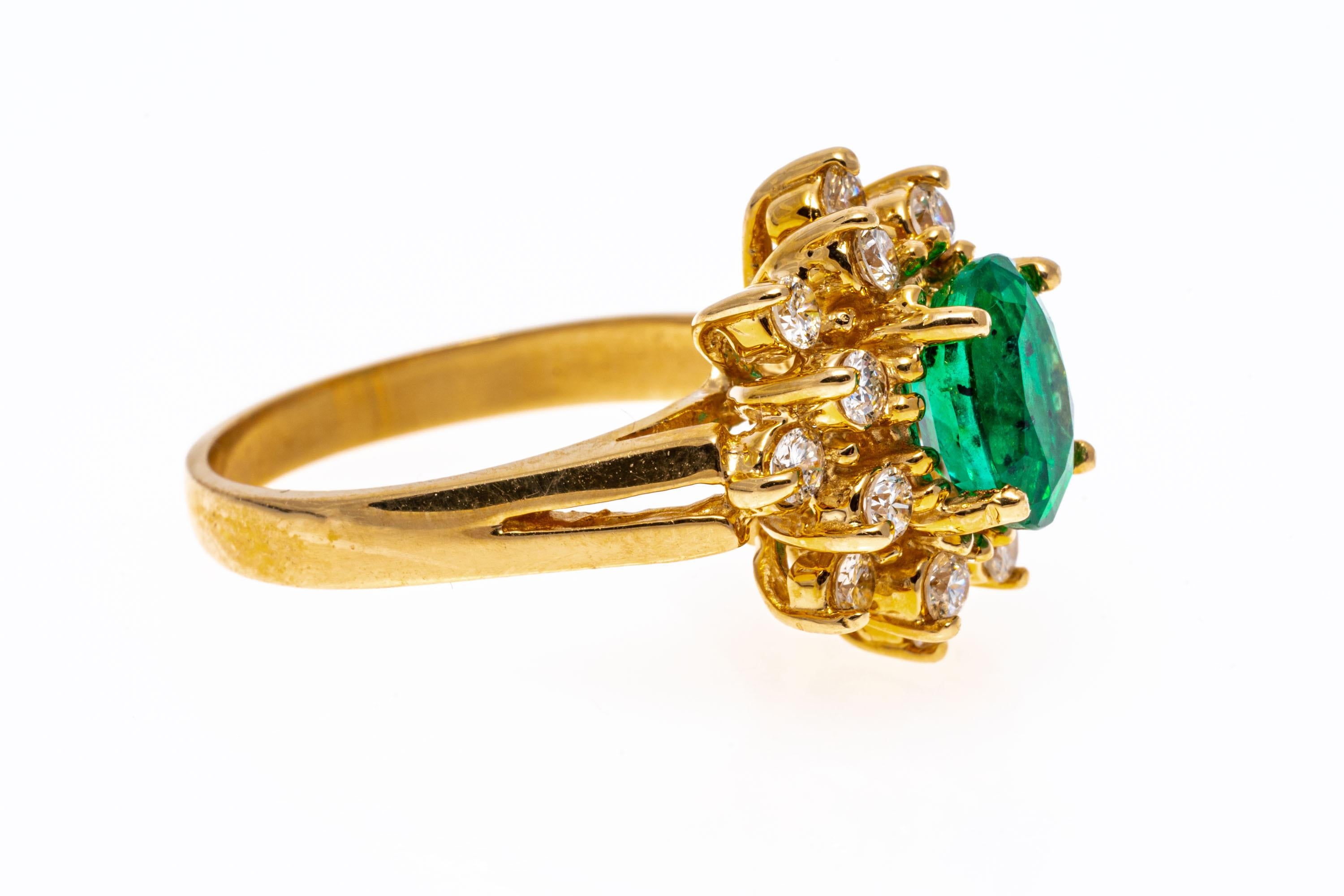14k yellow gold ring. This lovely ring has a center oval faceted, medium green color emerald, approximately 0.86 CTS and prong set, surrounded by a double halo of round brilliant faceted diamonds, approximately 0.40 TCW, and also prong set. The ring