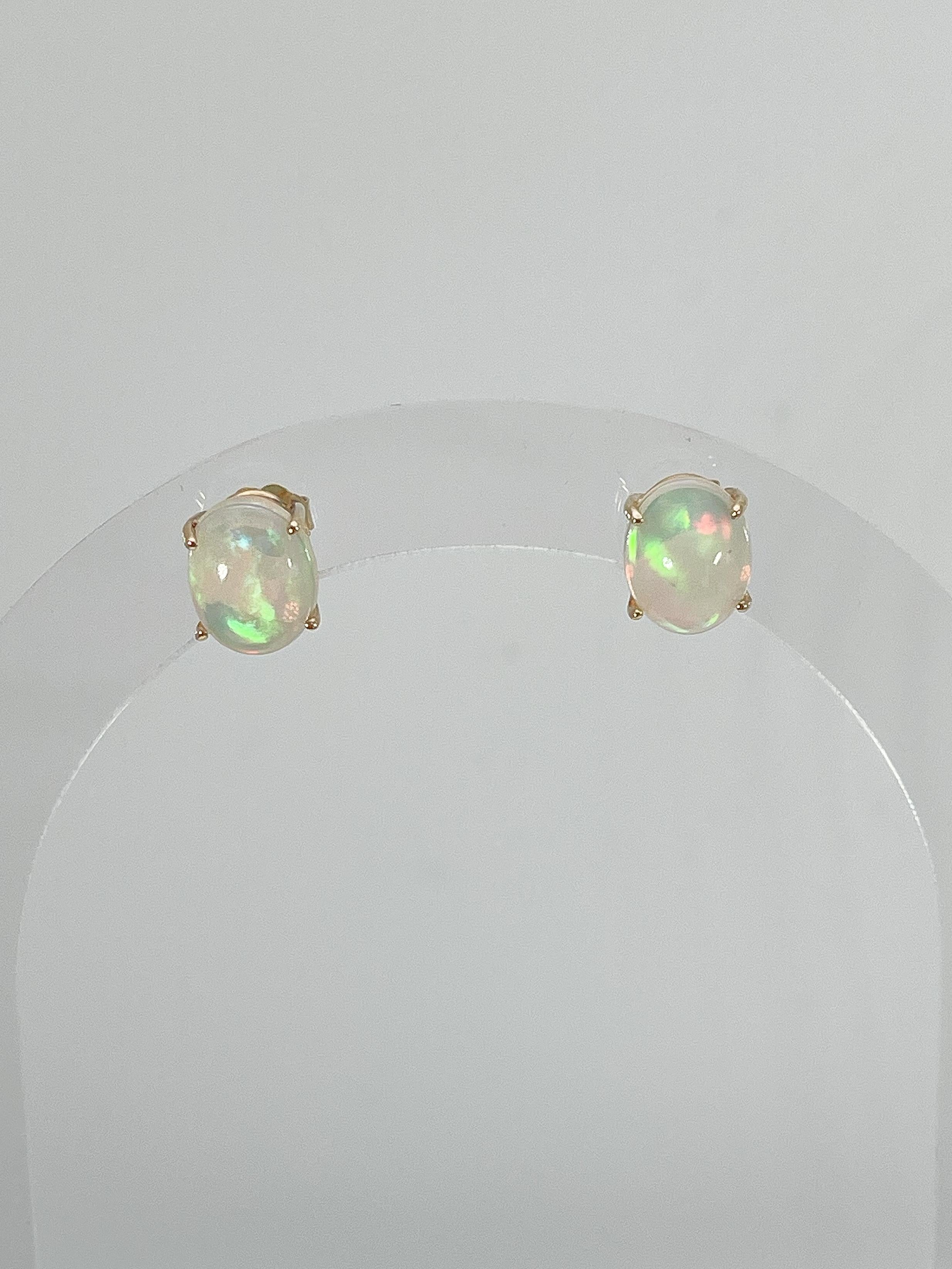 14k yellow gold oval opal stud earrings. These earrings have a measurement of 10 x 8 mm, and they have a total weight of 2.06 grams.