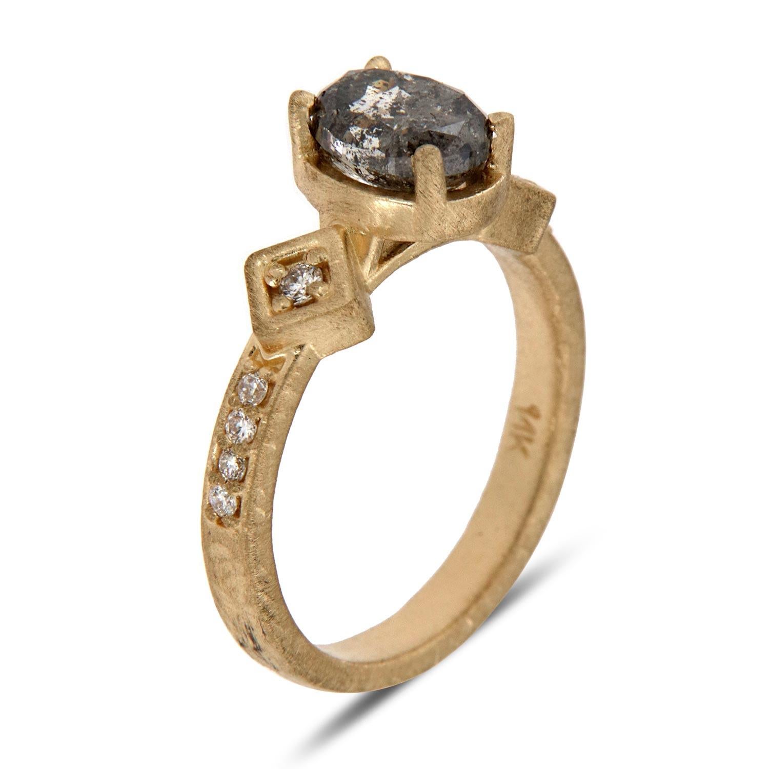 This Earthy design ring features Ten (10) Round brilliant diamonds prong set on a 2.3 mm matte-finished shank. In the center of the ring is set a 1.44 Carat Oval shaped natural Salt & Pepper diamond. The unique texture that we applied to the band