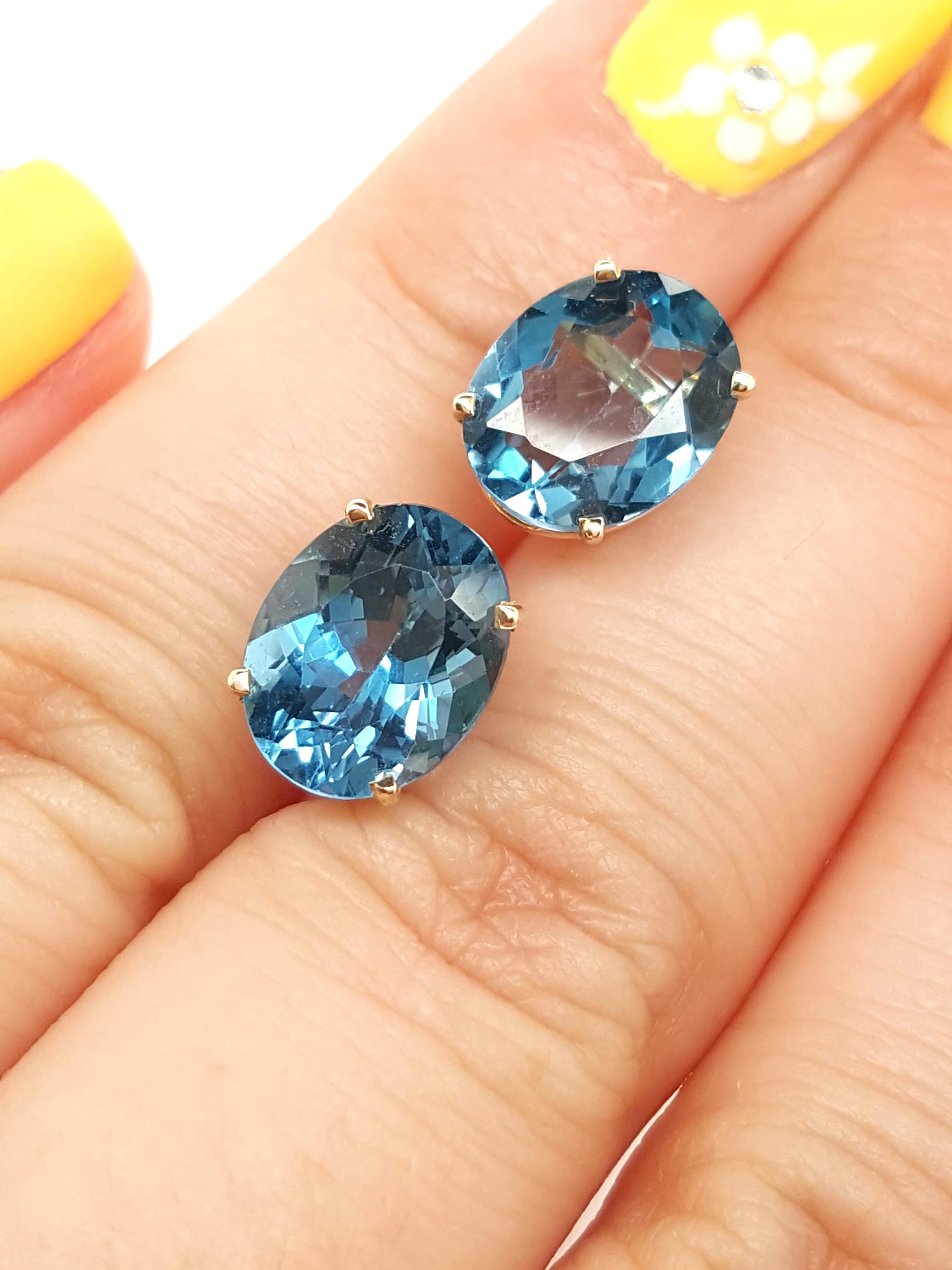  14 Karat Yellow Gold Oval Shaped Blue Topaz Stud Earrings   The earrings feature a matched pair of faceted oval shaped blue topaz weighing approximately 5.69 carats.  The blue topaz are each set into a 14 karat yellow gold four prong basket,