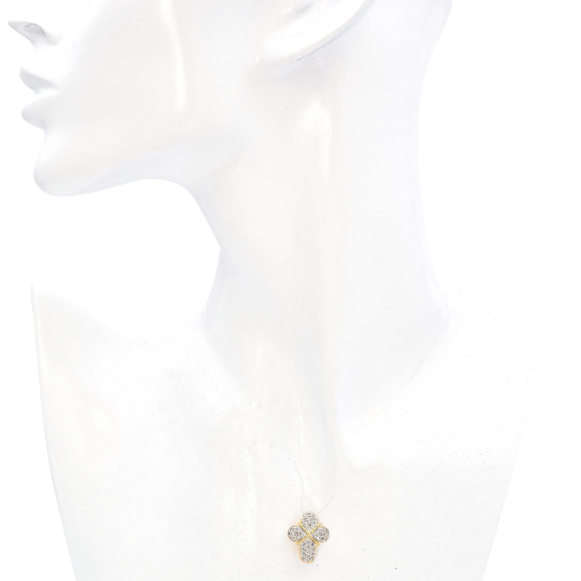Ce pendentif croix contemporain est réalisé en or jaune 14k et orné de diamants blancs ronds sertis en pavé. La pièce est structurée par une monture en or qui souligne élégamment les grappes de diamants.

Poids : 2,6 grammes
Pierre : diamant de 0,69