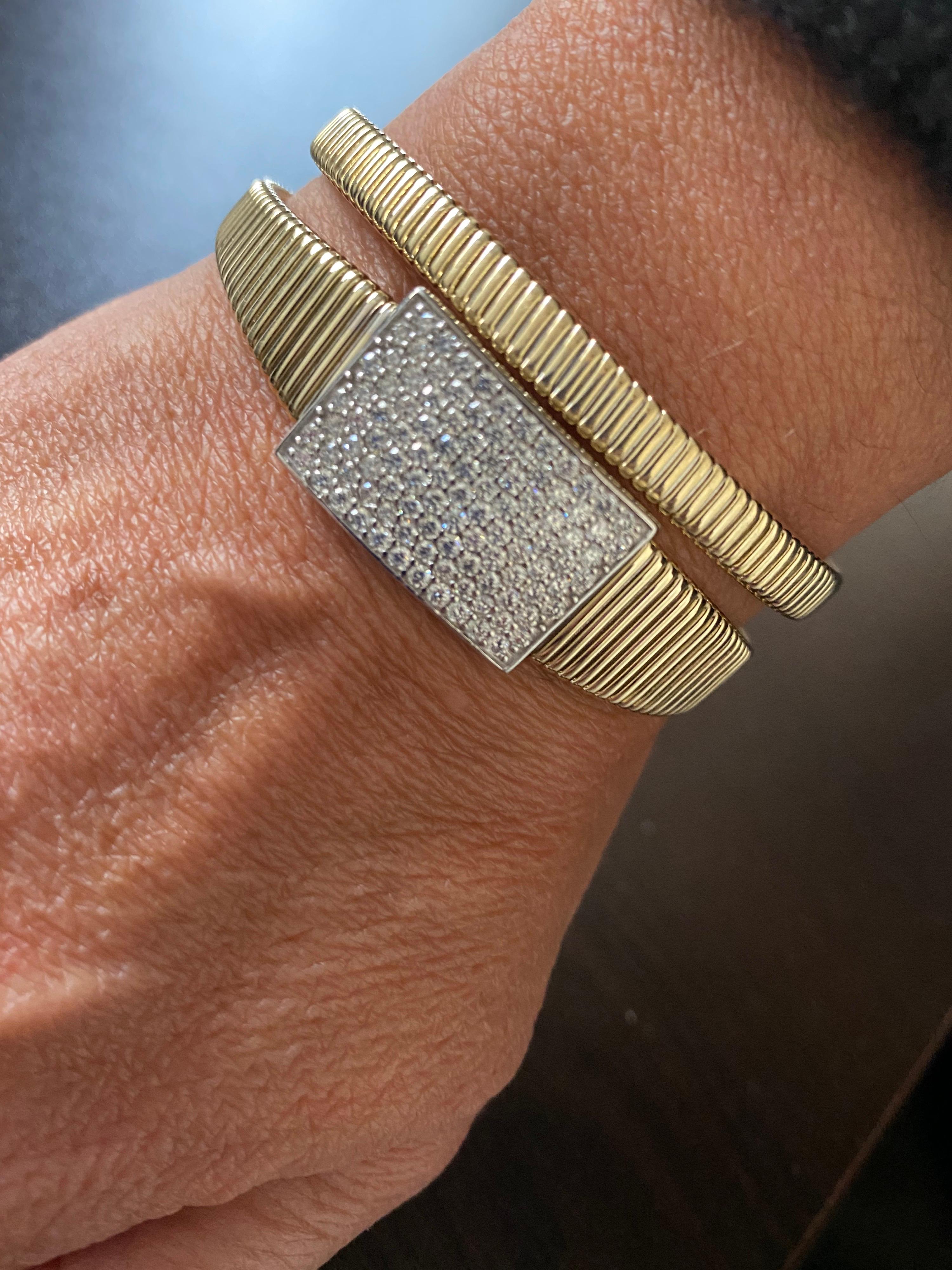 Flexible diamond pave' setting bangle set in 14K yellow gold. The total carat weight of the bangle is 2.23 carats. The color of the stones are G, the clarity is VS1-VS2. This magnificent piece is manufactured in Italy.