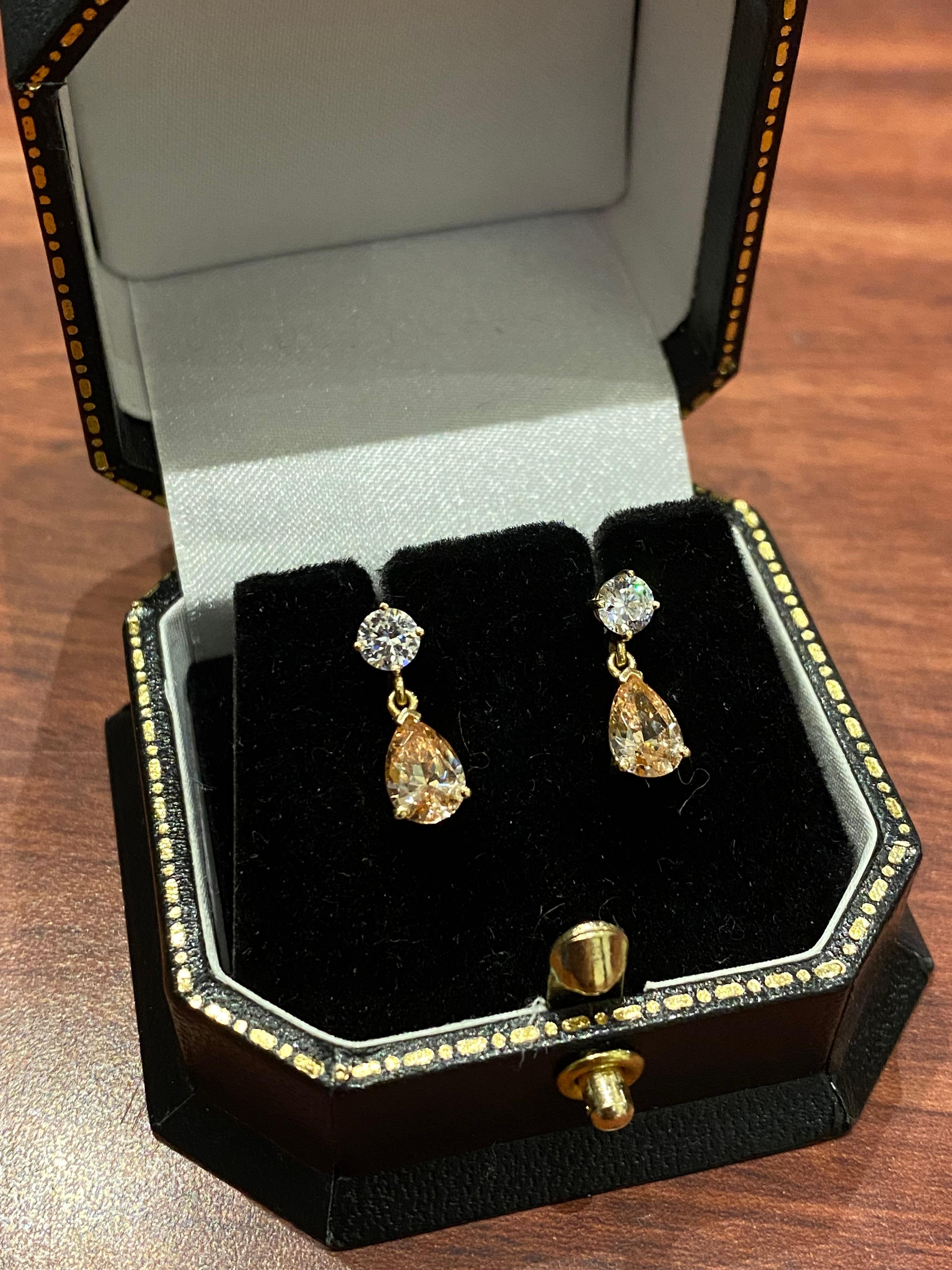 Each set with a striking pear-shaped 
peach coloured CZ &
sparkling round white CZ
crafted in 14K yellow gold (stamped 585)

Total item's weight: 1.5gr. 
Length: 15mm 