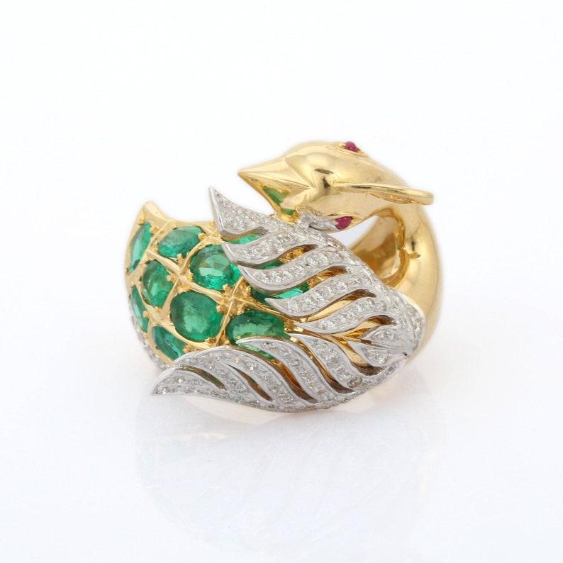 Emerald, Ruby and Diamond Peacock Cocktail Ring in 14K Gold featuring natural emerald and ruby of 1.76 carats and diamonds of 0.71 carats. The gorgeous handcrafted ring goes with every style.
Emerald gemstone enhances the intellectual capacity of