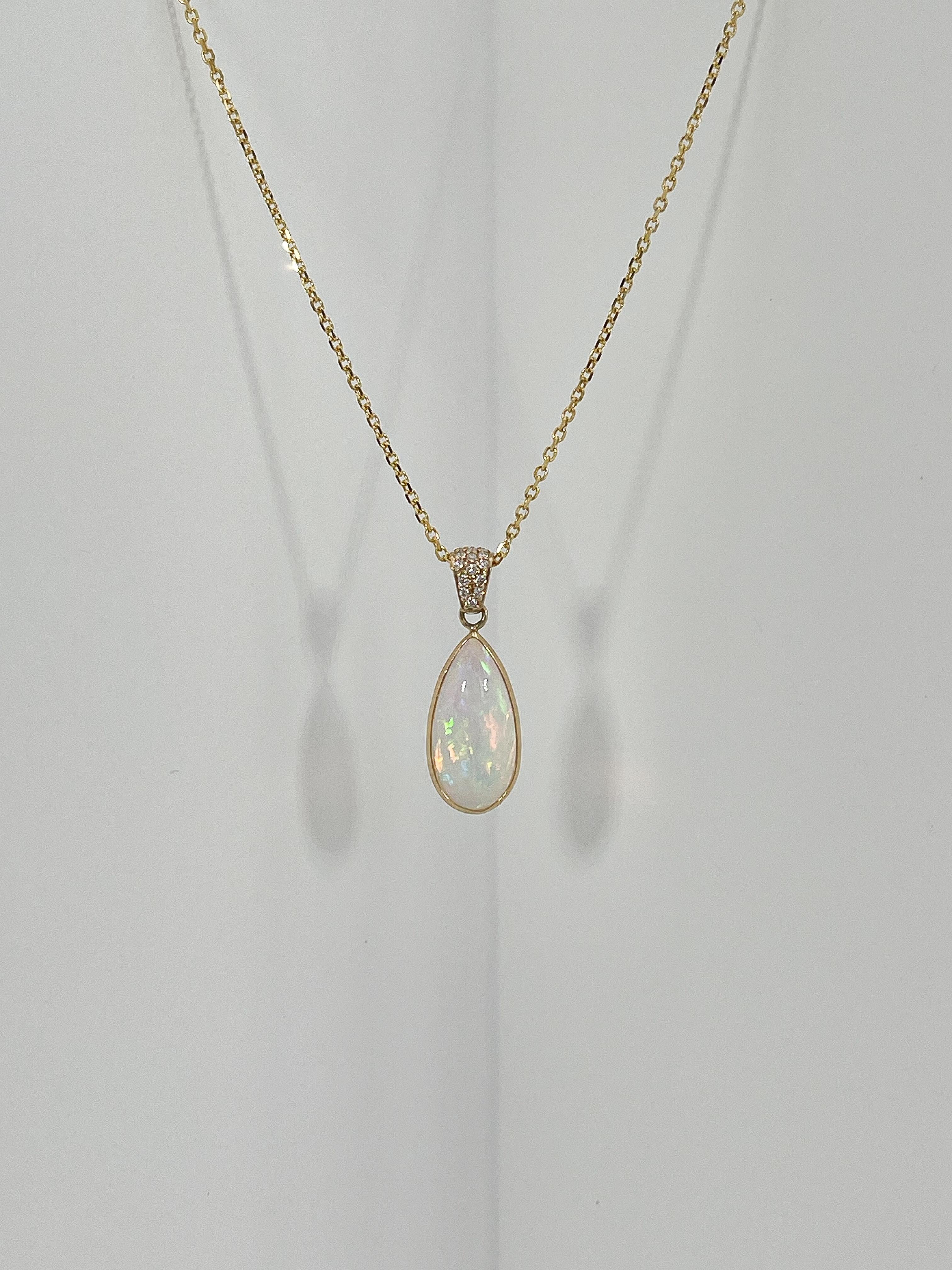 Collar colgante de oro amarillo de 14k con ópalo pera y diamantes de 0,07 qt. Los diamantes de la fianza son todos redondos, las medidas del colgante son 17,5 x 8,5 mm, la longitud del collar es de 20 pulgadas, y tiene un peso total de 3,75 gramos.