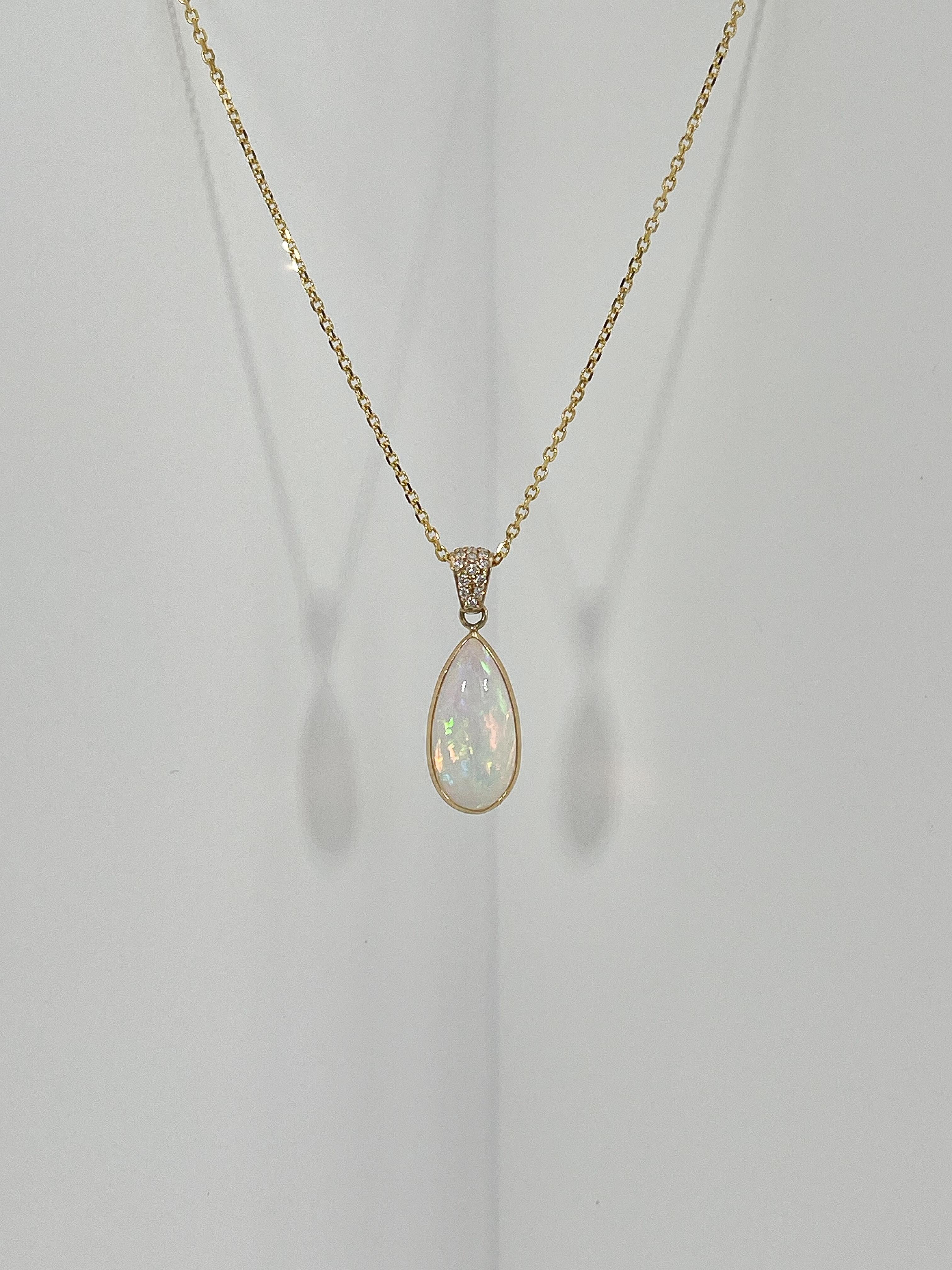 14k yellow gold pear opal and .07 Ct diamond pendant necklace. The diamonds in the bail are all round, the measurements of the pendant are 17.5 x 8.5 mm, the length of the necklace is 20 inches, and has a total weight of 3.75 grams.