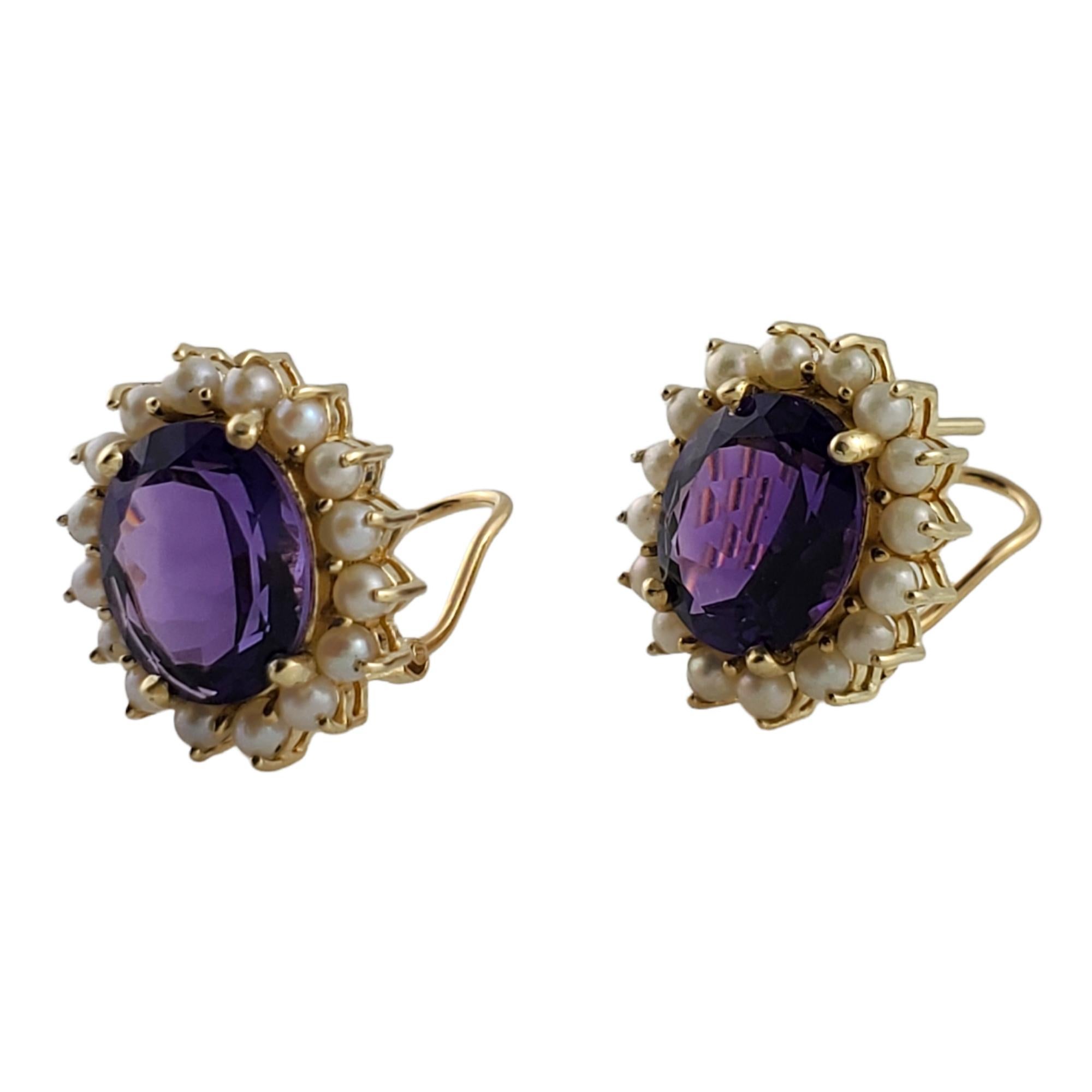 Gorgeous pair of yellow gold earrings featuring a 7 mm X 9 mm amethyst stone in the center surrounded by 16 pearls (on each earring).

Omega back closures.

Amethyst total weight: 7.36 ct.

Size: 13 mm X .mm

Weight: 8.5 g/ 5.4 dwt

Hallmark: 585