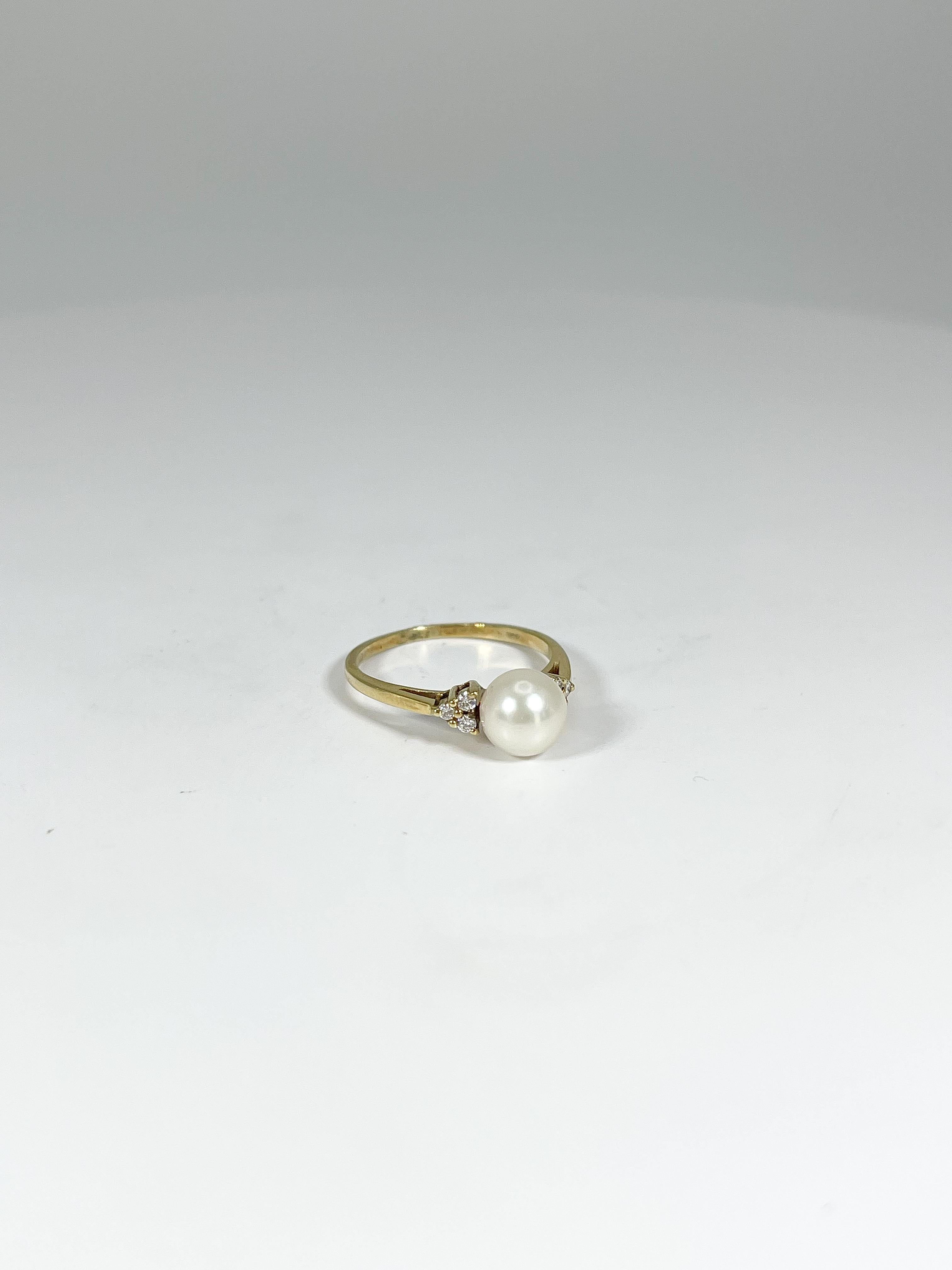 14k yellow gold pearl and diamond ring. Pearl is in the center and there are three diamonds on either side of the pearl. The ring is a size 6 1/4, the pearl has a diameter of 6.8 mm, and the ring has a total weight of 2.07 grams. 