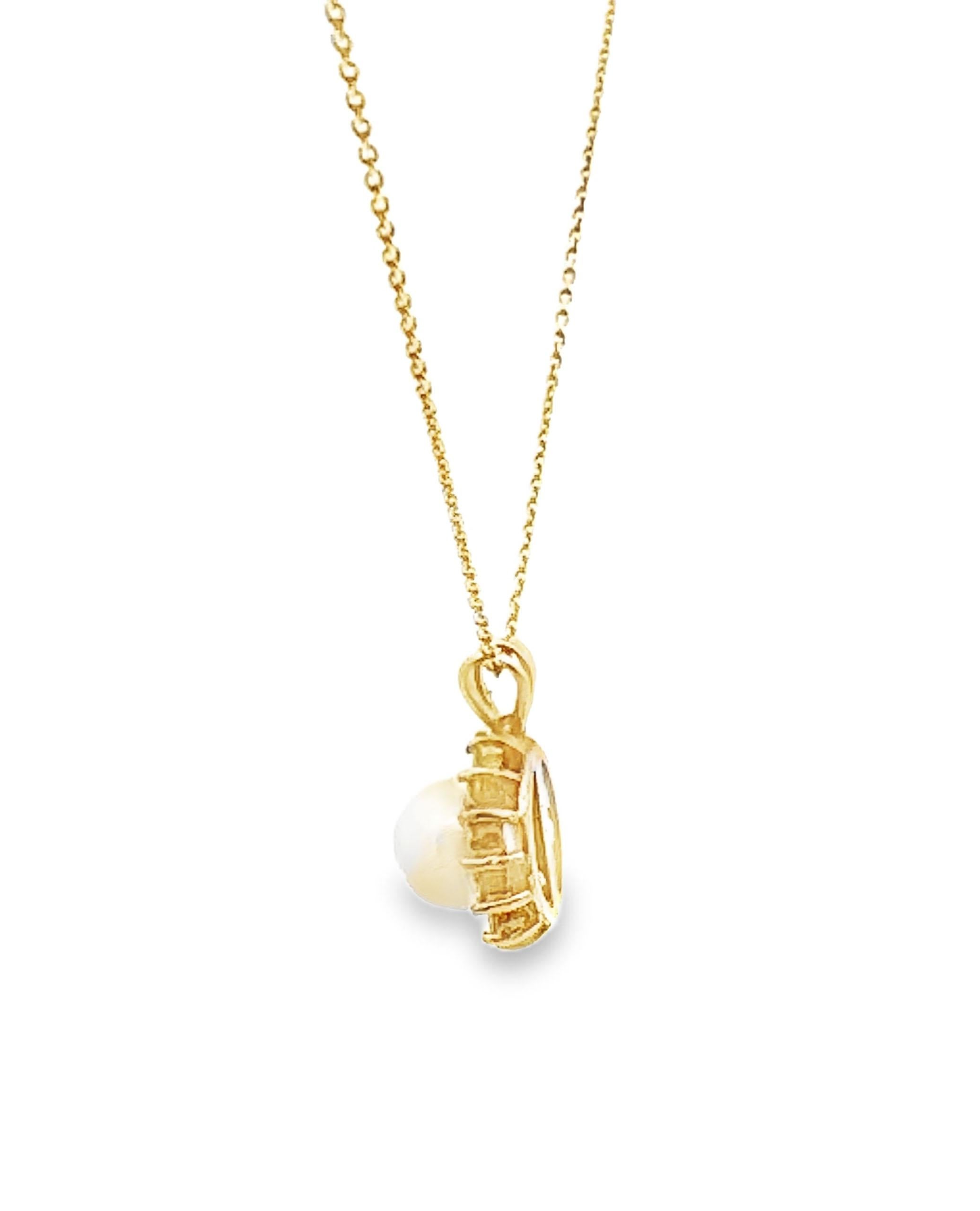Pre-Owned 14K yellow gold pendant furnished with 14 round faceted diamonds weighing approximately 0.25 ct total and one center 6mm cultured pearl. The pendant slides on a 14K yellow gold cable chain, 16 inches long.

