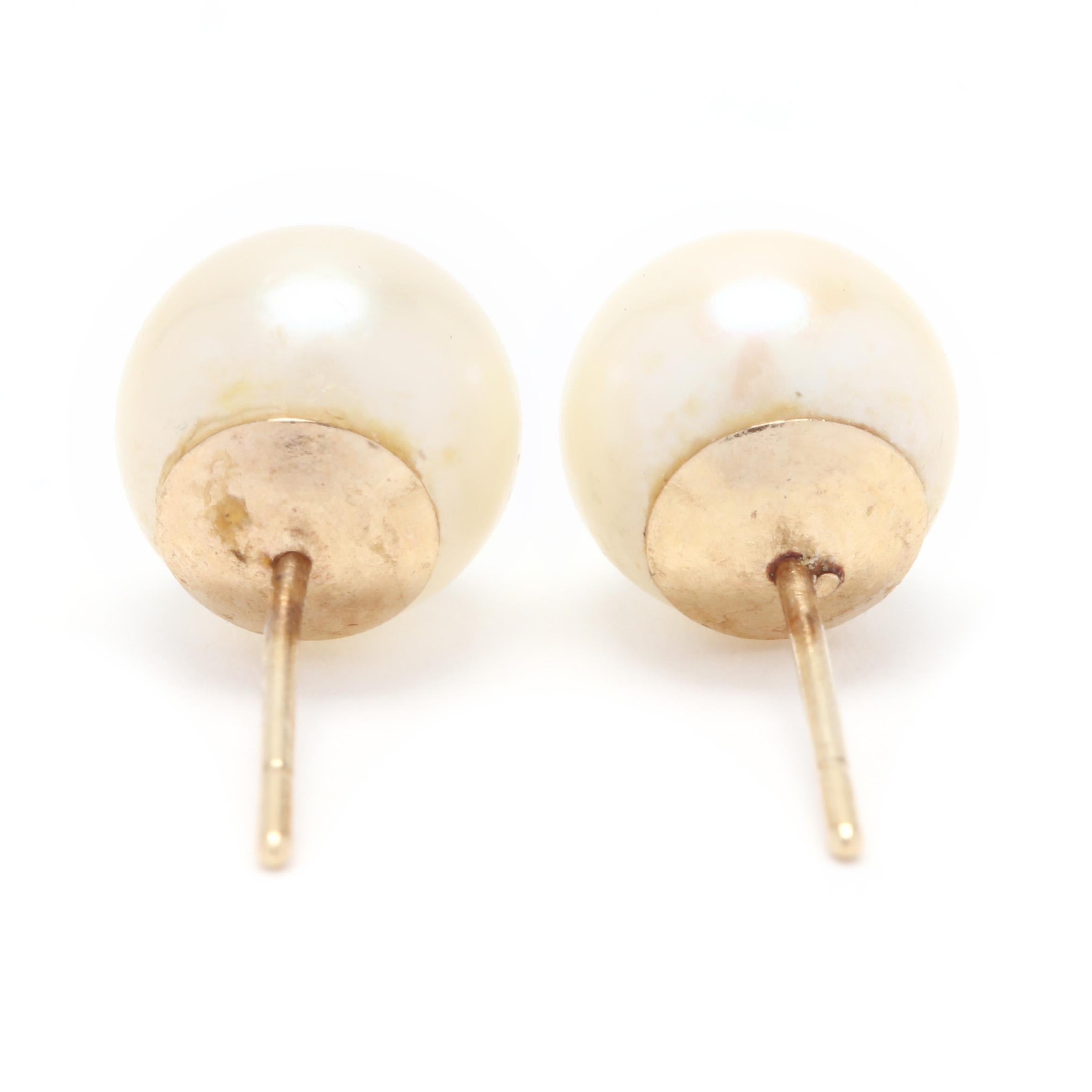 A pair of 14 karat yellow gold and pearl stud earrings. These earrings feature two round cream pearls (7.15 mm) with rose overtones, good luster and with push backs.

Stones:
- pearls
- round bead, 2 stones
- 7.15 mm

.91 dwts.

* Please note that