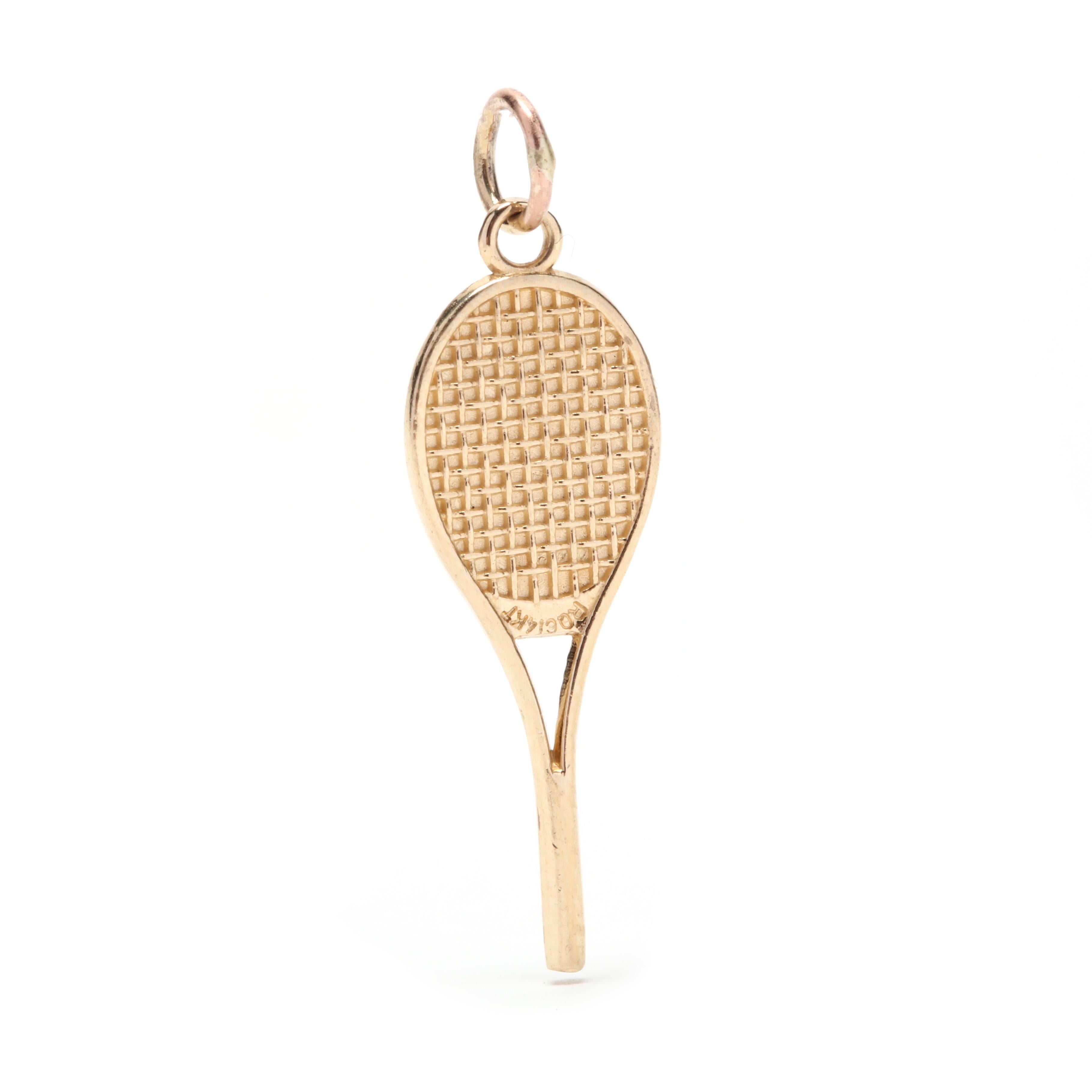 A 14 karat yellow gold and pearl tennis racket charm / pendant. This charm features a tennis racket motif with etched detailing and a white pearl bead in the center.

Stones:
- pearl, 1 stone
- round bead
- 2.15 mm

Length: 1 1/8 in.

Width: 3/8