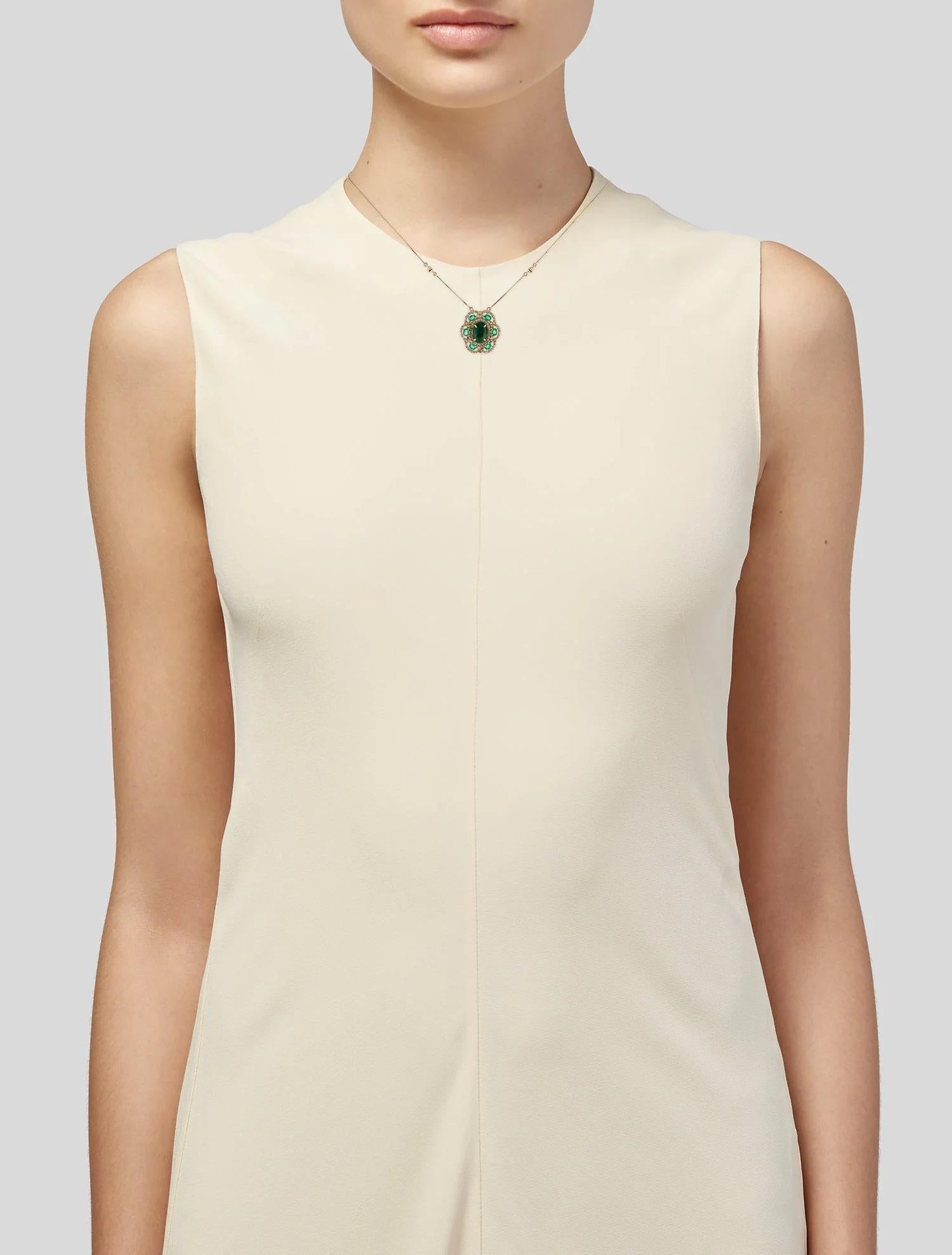 This elegant 14K yellow gold pendant necklace highlights a captivating 0.64-carat oval brilliant emerald, framed with near-colorless diamonds and accented by colorless sapphires. With its harmonious blend of gemstones, this necklace is both a