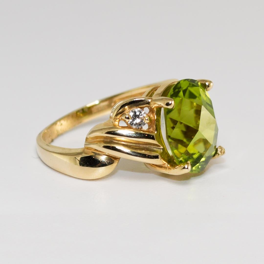 14k yellow gold Ladies' ring with a center 5.50 carat Peridot gemstone.
The center stone is an intense yellowish-green with fancy faceting on the top of the stone.
The cut is excellent and the stone is very bright in color.
On each side are two