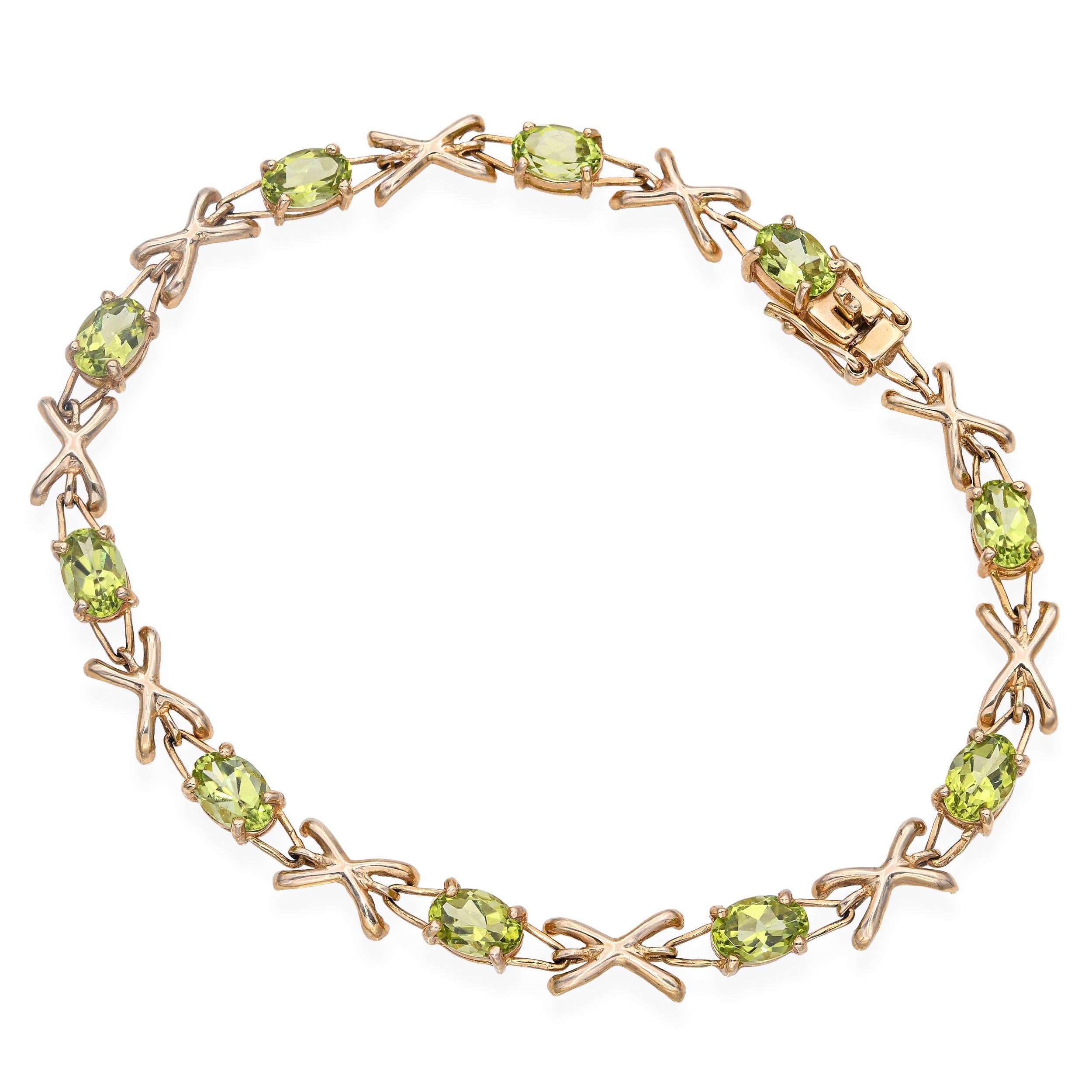 Ce bracelet de tennis en or jaune 14k offre une élégance fraîche et raffinée grâce à sa présentation éclatante de pierres précieuses péridot. Chaque pierre est soigneusement sertie en 
