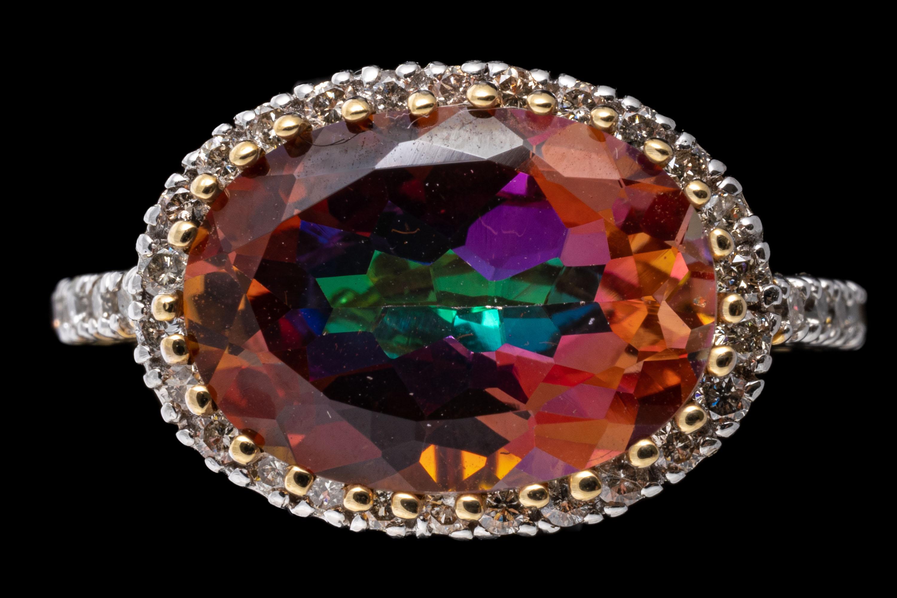 14k yellow gold ring. This striking ring has a horizontal oval faceted, pink mystic topaz center, set with an ornate prong decoration and framed with a halo of round faceted diamonds, that extend down the shoulders, 0.40 TCW.
Marks: 14k
Dimensions: