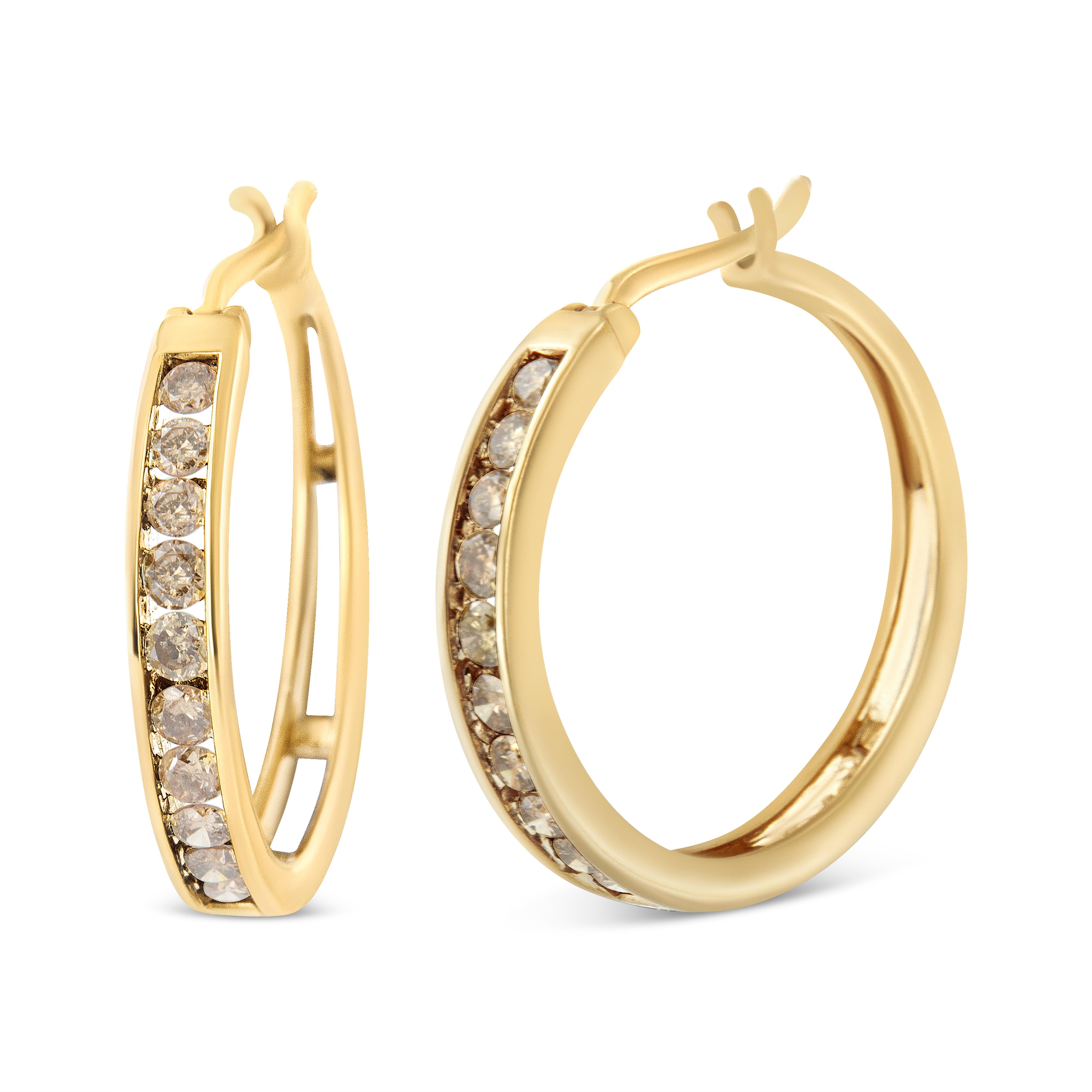 Modern and elegant, these glamorous hoops are created in sparkling 14kt yellow gold plated 925 sterling silver. The outer part of these earrings are beautifully set with champagne color diamonds in classic shared prong settings. The diamonds are