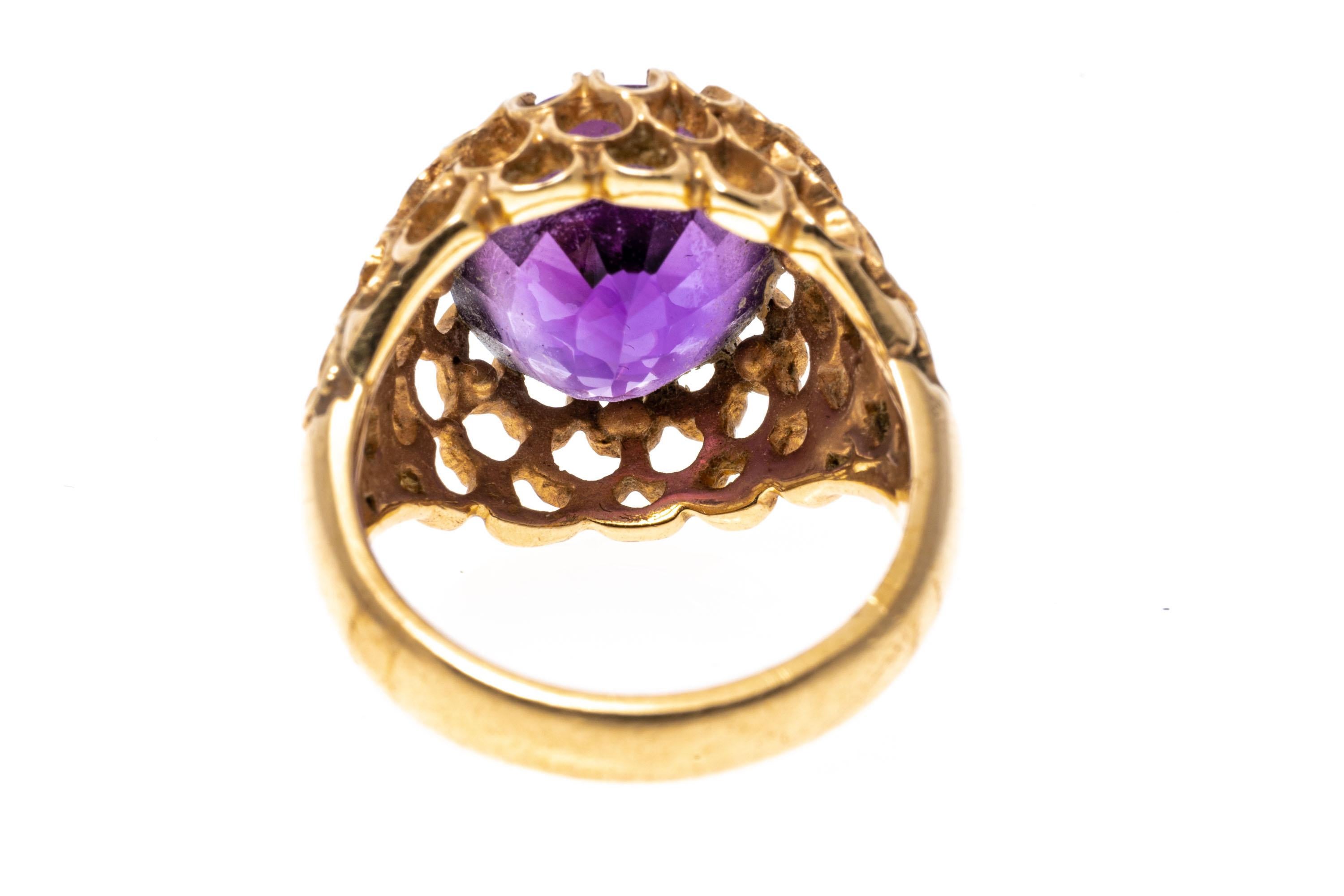 14k yellow gold ring. This wonderful ring has an oval faceted, medium to dark purple color amethyst, approximately 6.84 CTS and set into a wide, concentric open scalloped motif mounting.
Marks: 14k
Dimensions: 7/16