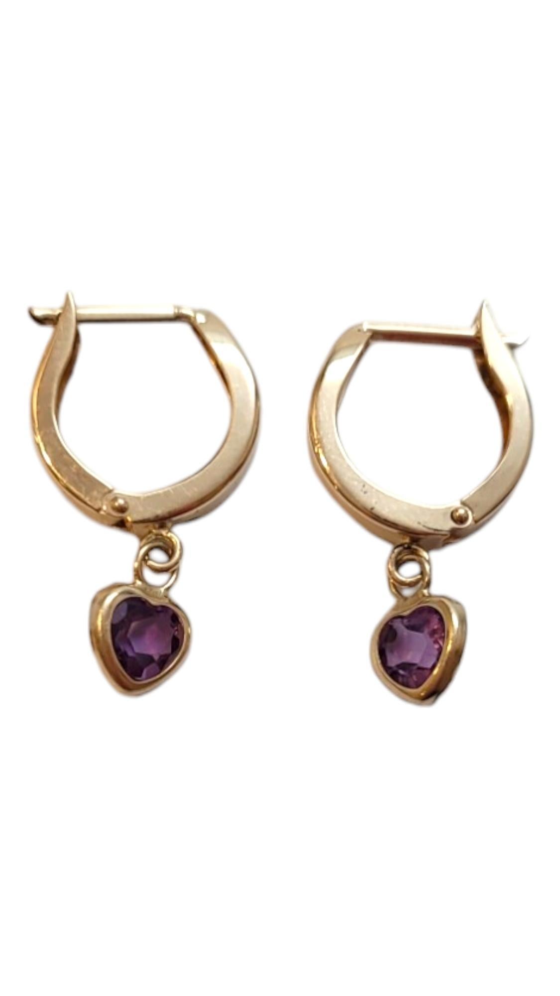14K Yellow Gold Purple Heart Hoop Earrings - 

Elevate your elegance with our gorgeous hoop earrings that are accented with dangling purple heart shape stones. 

Size: 22.33mm X 2.65mm

Weight: 0.78 dwt/ 1.21 g

Hallmark: FI 14K

Very good