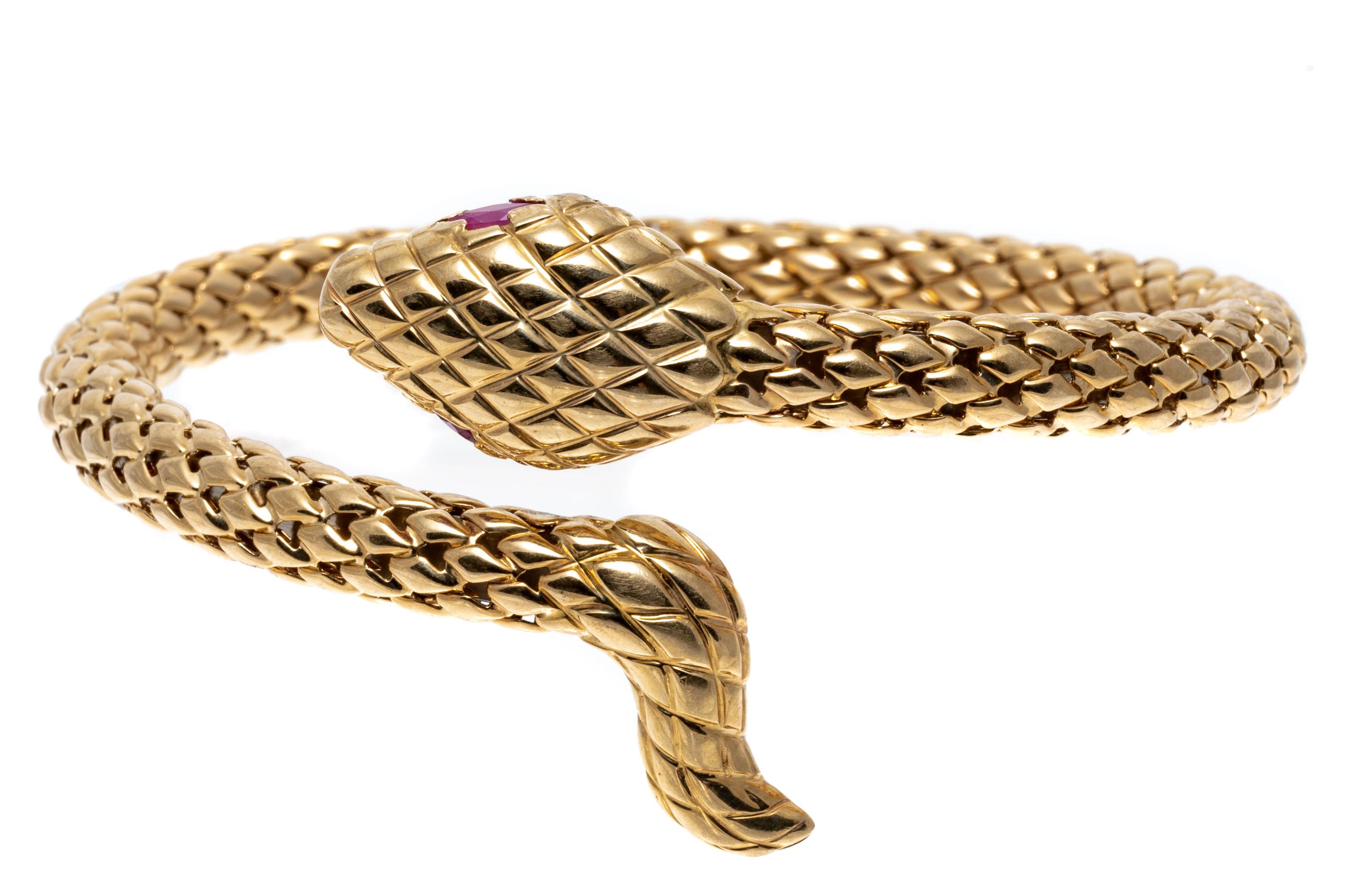 14k yellow gold bracelet. This bold bracelet is a springed tube coil style in the form of a snake, patterned with a quilted finish, head to tail, and set with marquise shaped pinkish red ruby eyes, approximately 0.26 TCW.
Marks: 14k
Dimensions: 2