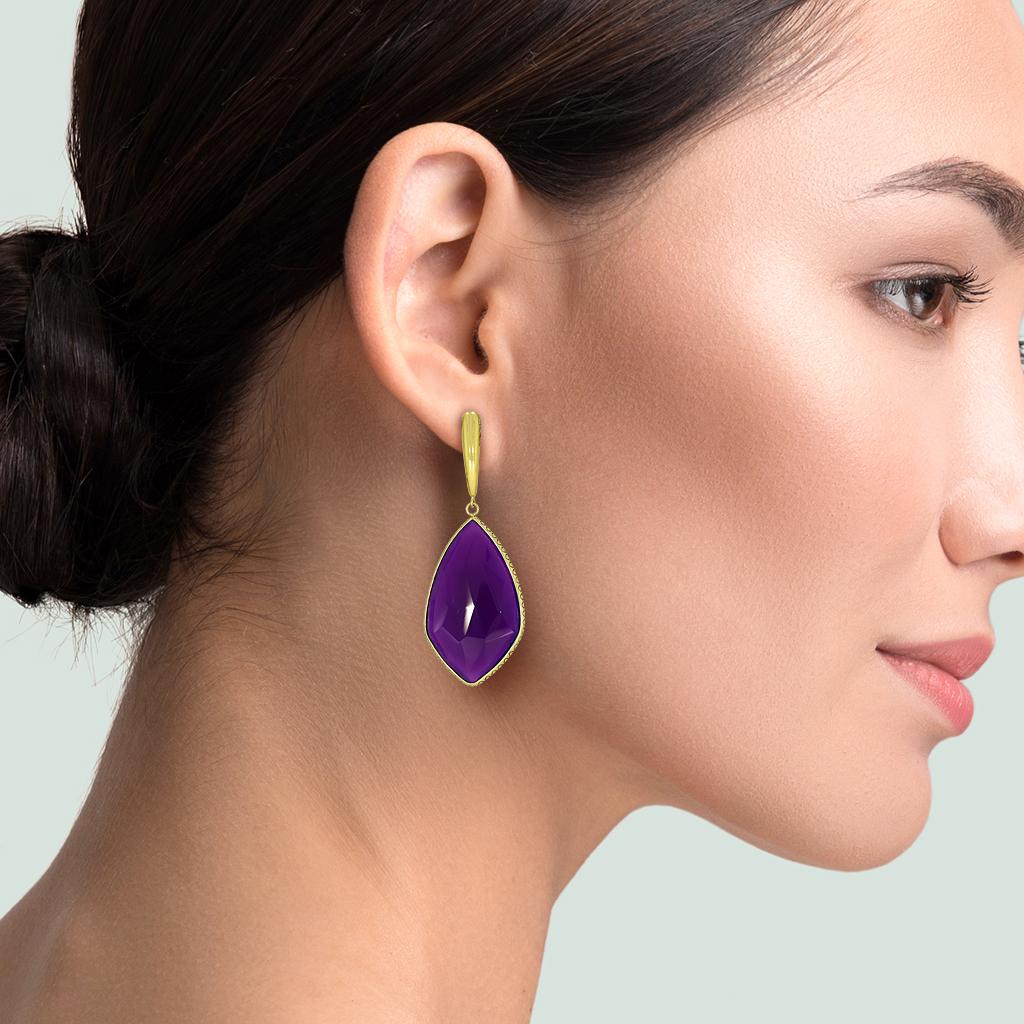 For the serious collector of rare gemstones. These larger high quality gel sugilite are a spectacular example of this hard to find gemstones in a highly crafted 14K yellow gold drop earring setting. Photo 4 shows transmissive light from behind.