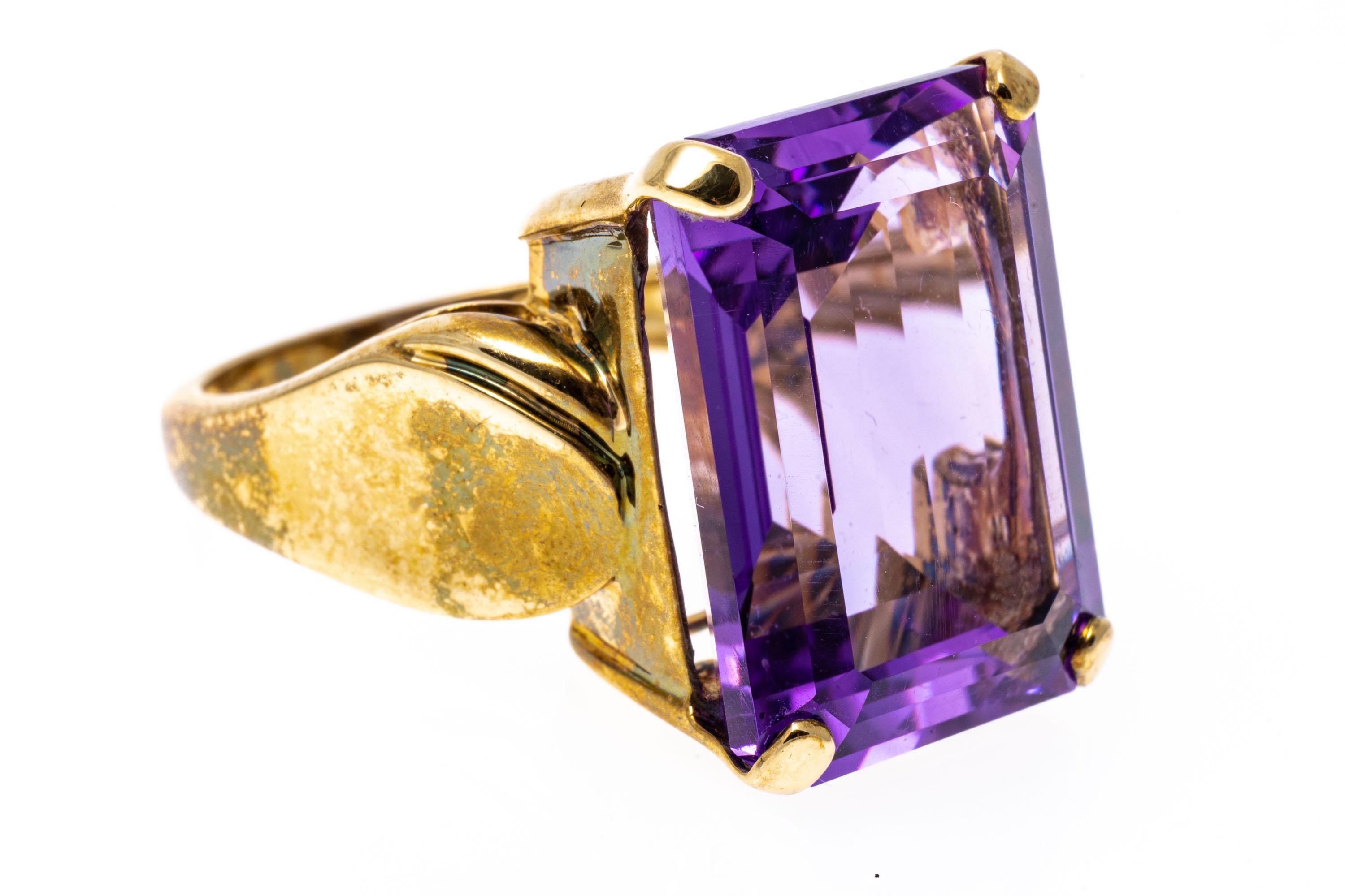 bague en or jaune 14k. Cette bague saisissante présente une améthyste rectangulaire à facettes, de couleur violet moyen à clair, d'environ 12,07 CTS, sertie à la griffe et décorée par des côtés convexes en forme de cuillère hautement polis.
Marques