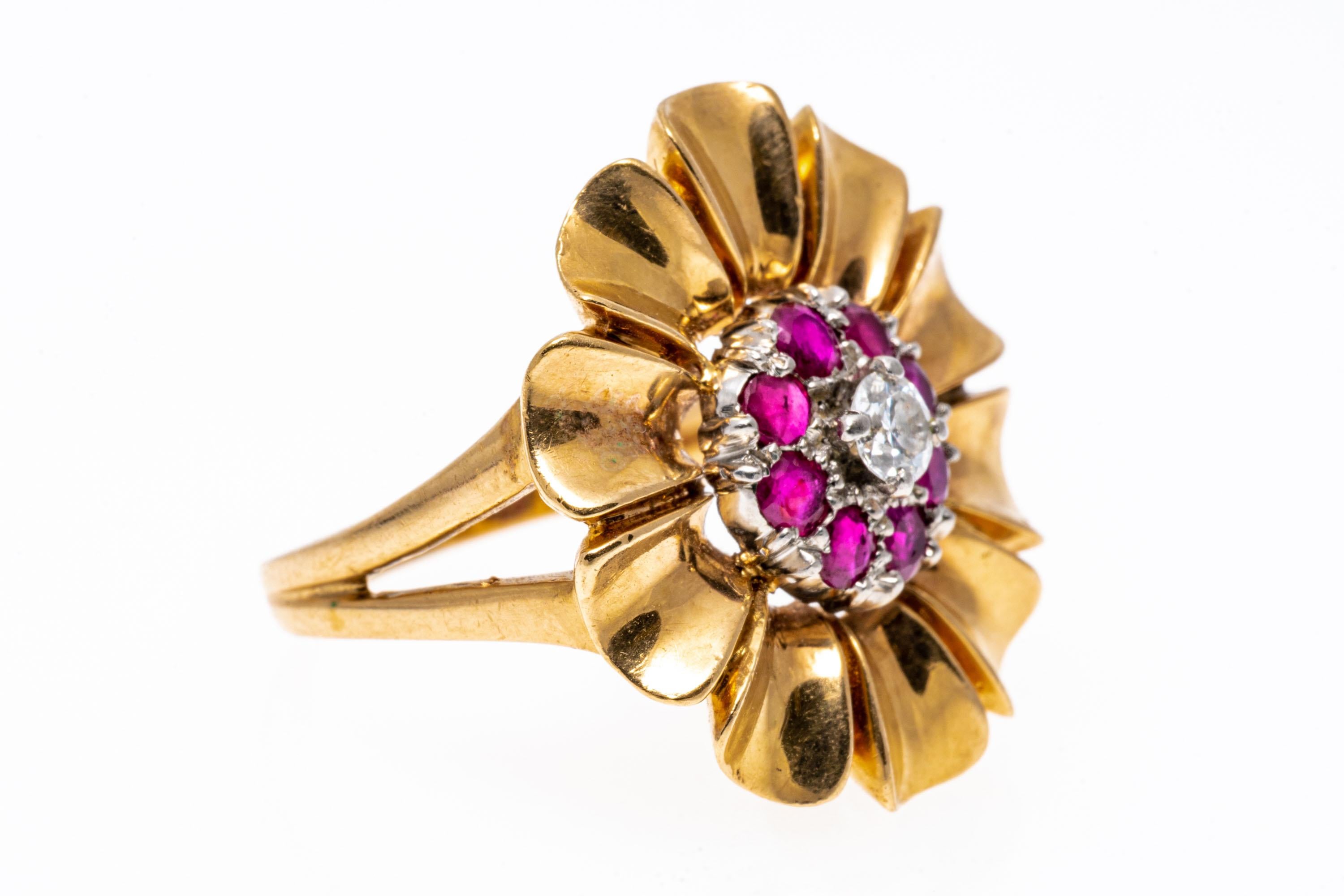14k yellow gold ring. This beautiful retro flower motif ring features concave, highly polished petals, decorated in the center with a round brilliant cut diamond, approximately 0.10 CTS, framed with a round faceted, pinkish red color ruby halo,