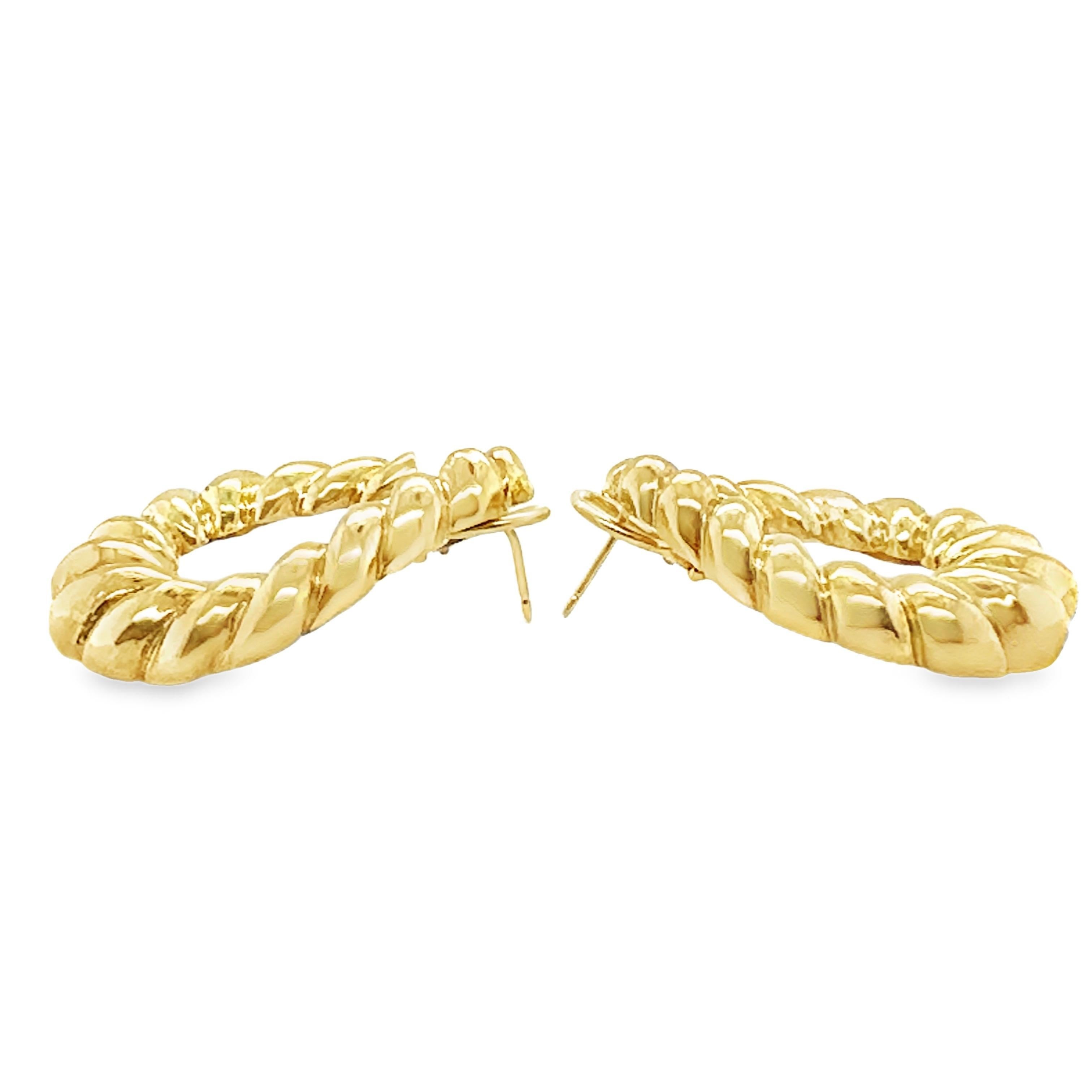 This timeless pair of 14K yellow gold hoop earrings from the 1960s combines elegance with a bold design. Featuring a ribbed, high-polish finish, these hoops radiate a refined yet striking aesthetic, capturing the glamour of mid-century
