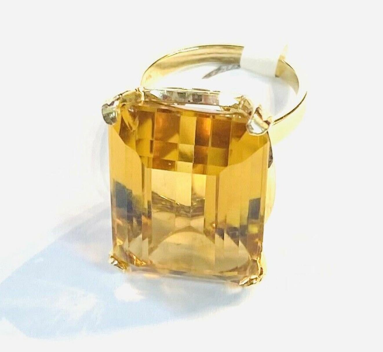 14k yellow gold emerald cut Citrine ring, 9.79 Grams TW. The dimensions of the emerald cut citrine are approximately 15 mm x 20 mm. Approximately 15 carats. Marked 14k. Approximate size 6.0.