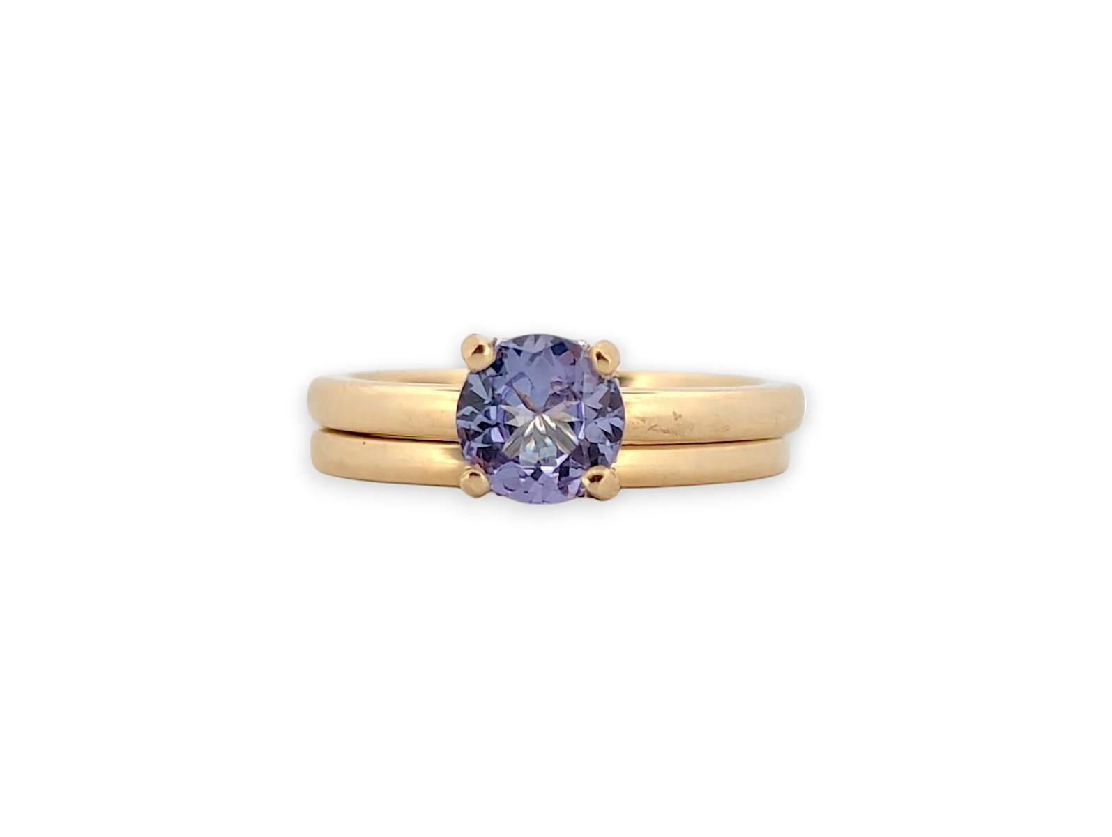 This exquisite 14K yellow gold ring set features a dazzling 1.20 CT tanzanite center stone, highlighted by a delicate .07 CTW natural diamond hidden halo. The deep blue-violet hue of the tanzanite beautifully contrasts with the warm yellow gold