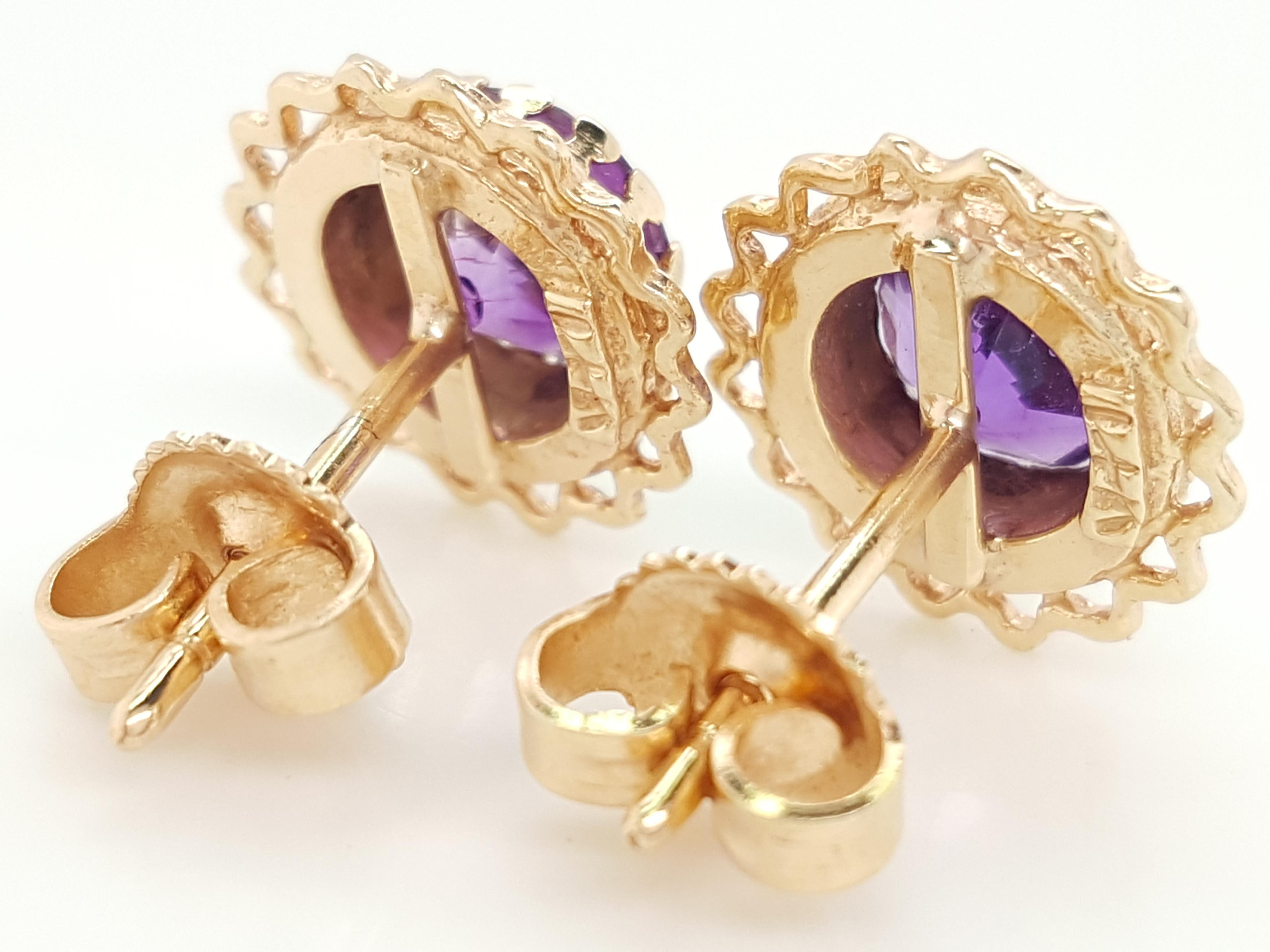  14 Karat Yellow Gold Round Amethyst  Bezel Set Stud Earrings   The earrings feature a matched pair of faceted round amethyst weighing approximately  1.55 carats.  The amethyst are each set into a 14 karat yellow gold bezel framed by a feminine