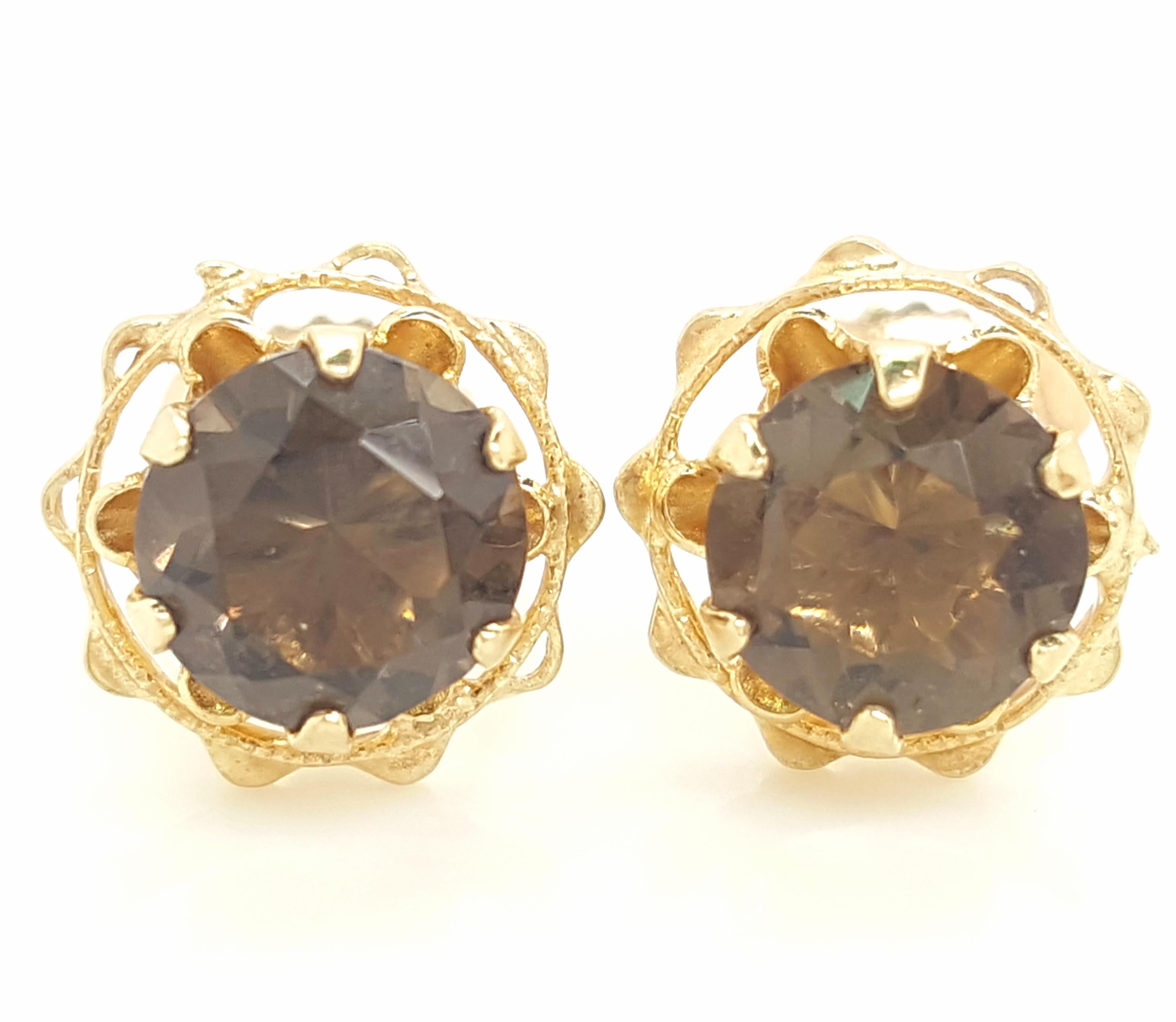 14 Karat Yellow Gold Round Smokey Quartz Stud Earrings.  The earrings feature a matched pair of faceted round smokey quartz weighing approximately  1.69 carats.  The quartz are each set into a 14 karat yellow gold six prong tulip setting with a