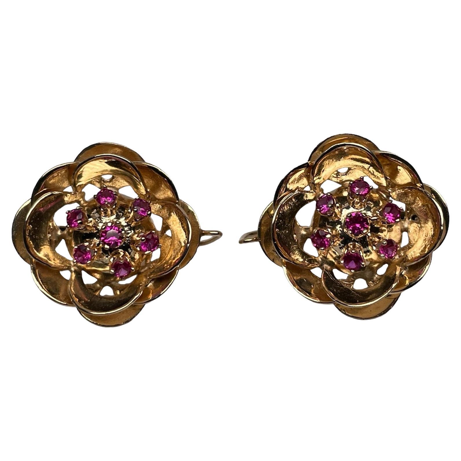 This is a pair of 14K yellow gold rubies earrings. They are finely shaped as a Camellia flower. Six rubies ( cm in diameter each one ) are exquisitely arranged in prong setting together in the center inside the flower cavity. They are hallmarked 14K
