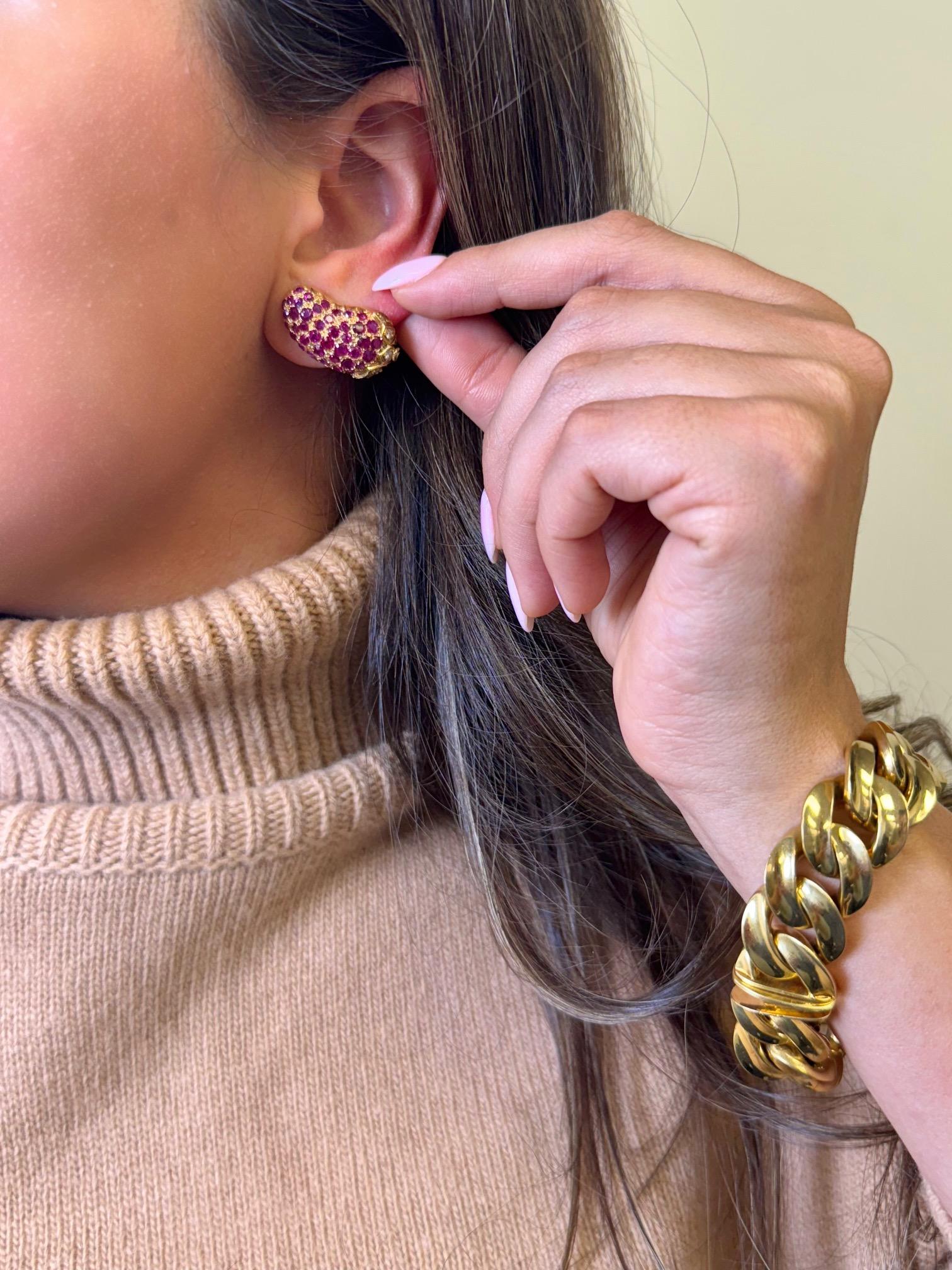 Playful meets opulent in these whimsical 14K yellow gold eggplant-shaped earrings. Paved with vibrant red rubies and accented by sparkling white diamonds at the leafy tops, these clip-on earrings are a delightful blend of fine craftsmanship and