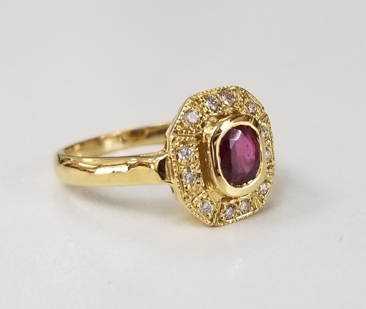 bague en or jaune 14k rubis et diamant, contenant 1 rubis de taille ovale de belle qualité pesant .50pts. et 12 diamants ronds de pleine taille de très belle qualité pesant .35pts. dans une bague de style 