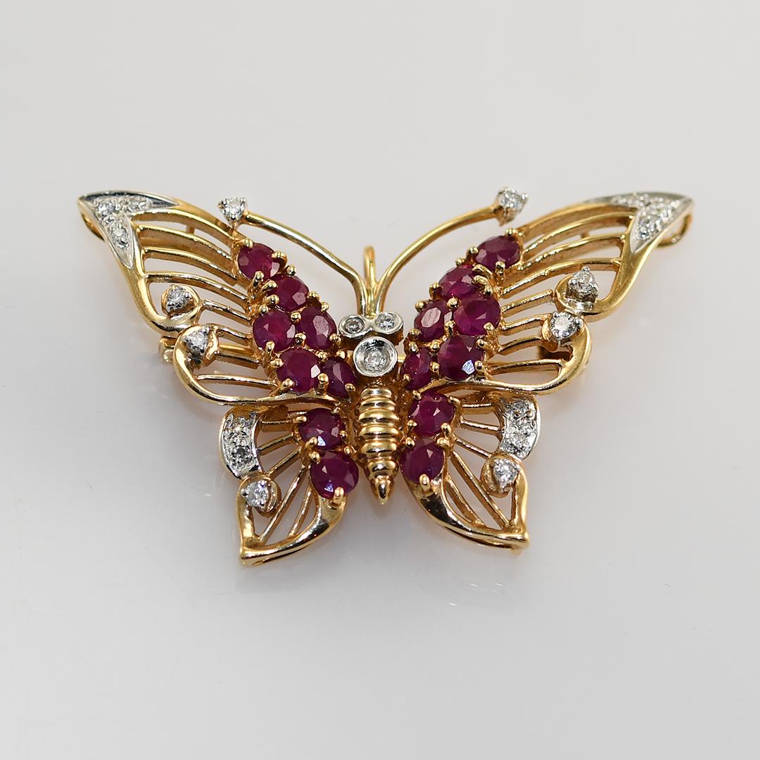 Broche papillon en or jaune 14k, rubis et diamants.

Estampillé 585 et pèse 5 grammes.

Il y a des rubis ronds taillés en brillant, bonne couleur, clarté opaque, 1,00 carats au total.

Minuscules diamants ronds sur les côtés, 0,10 carats au