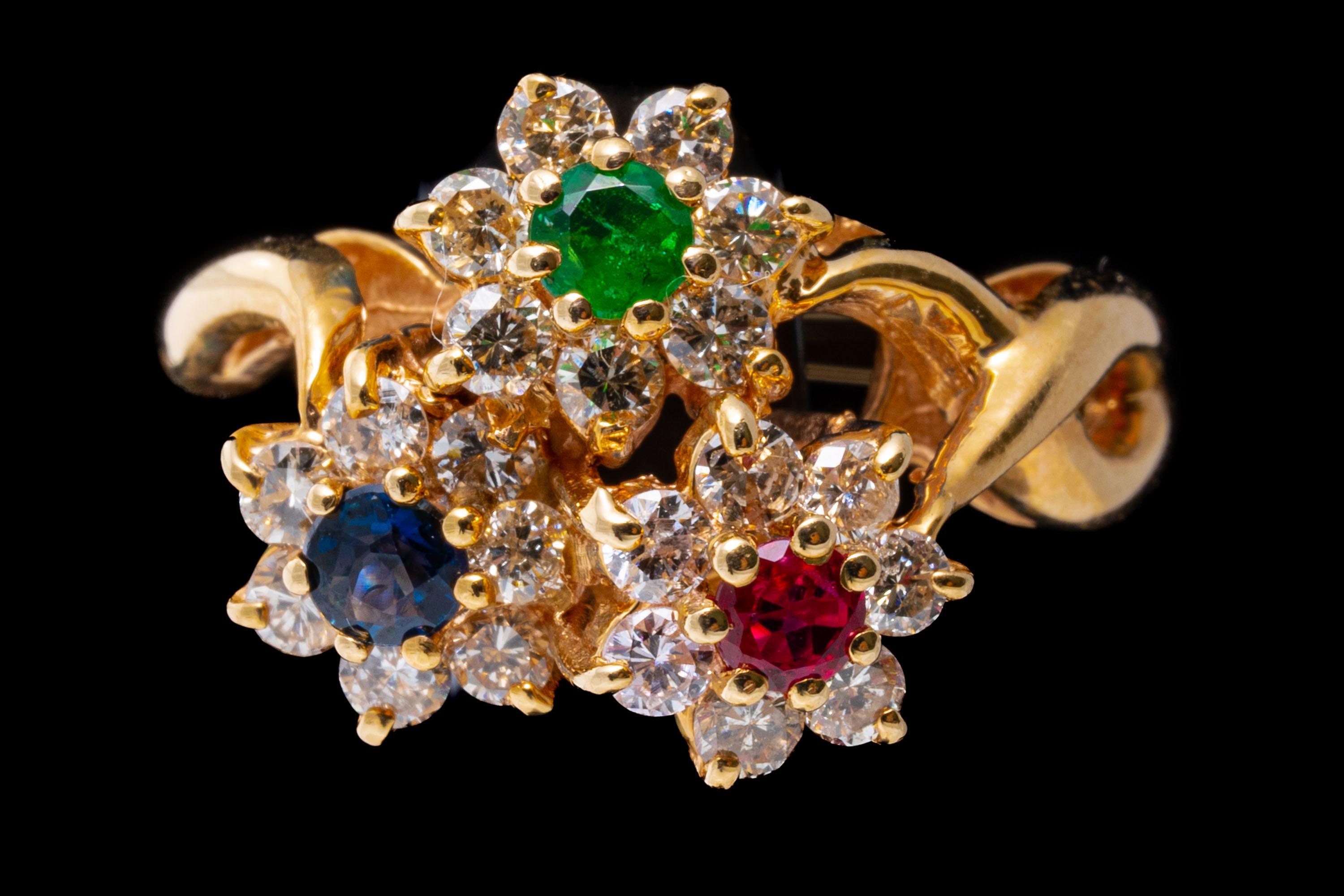 14k yellow gold ring. This beautiful yellow gold ring is a triple flower motif, set with a round faceted red ruby (approximately 0.12 CTS), a round faceted green emerald (approximately 0.10 CTS) and a round faceted blue sapphire (approximately 0.12