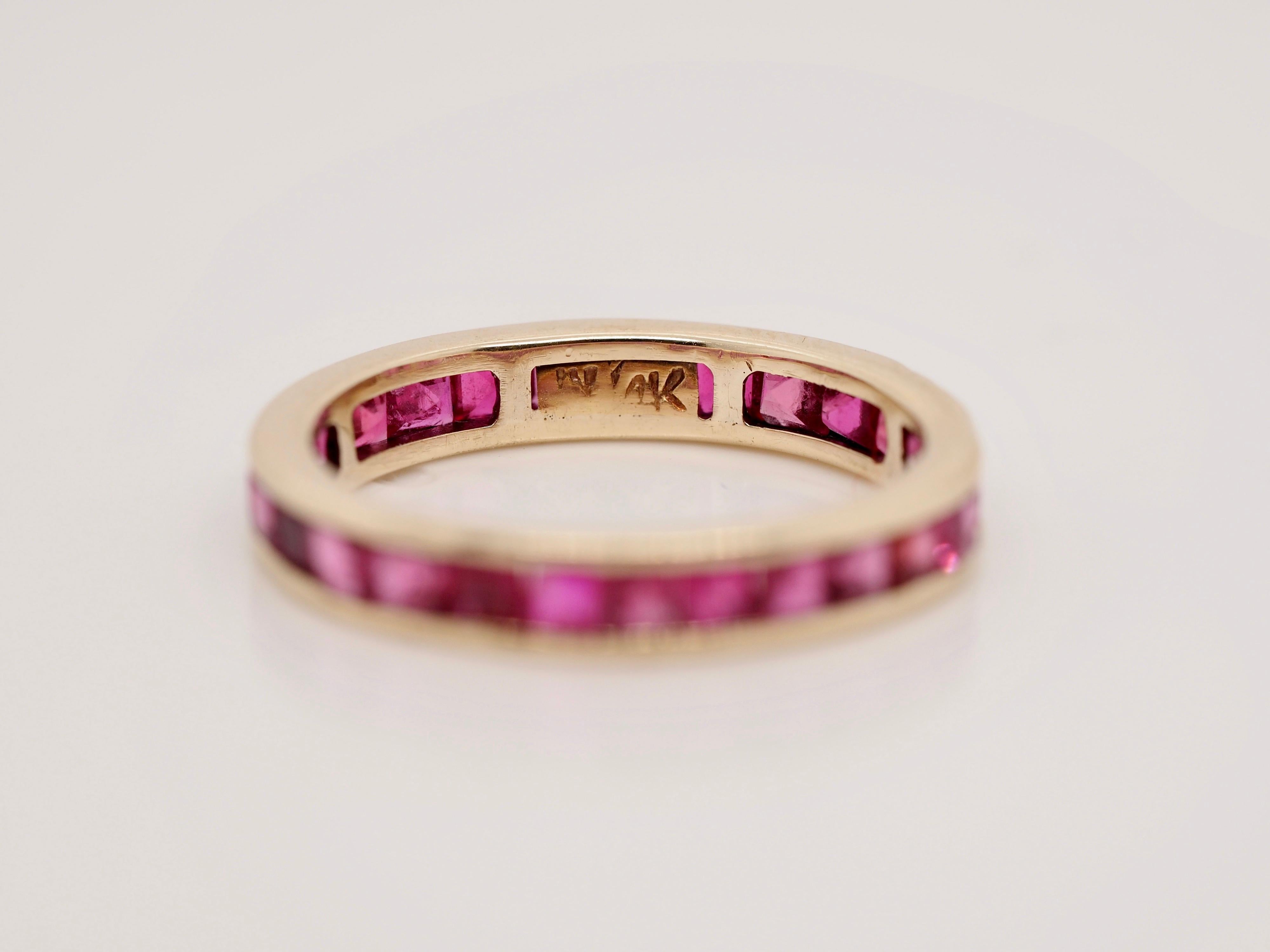 This piece is a great example of a vintage stackable ring! The smooth 14K yellow gold channel perfectly compliments the 3.78 carats of beautiful magenta princess cut rubies! There is a pierced open back pattern throughout the ring to allow light and