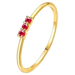 Anillo de oro amarillo de 14 quilates con rubí redondo de tres piedras