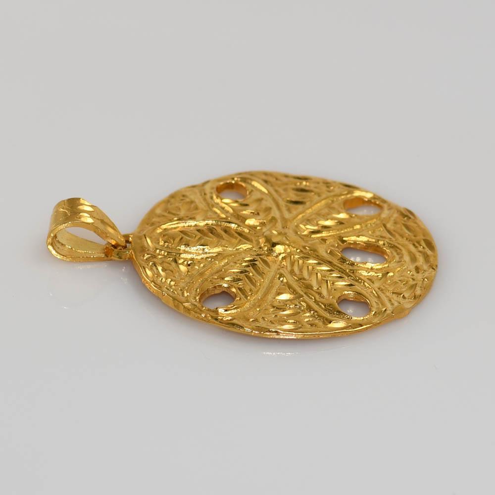 One 14KT yellow gold sand dollar pendant.
This pendant is stamped 14KT on the top of the sand dollar and is textured on both sides.
The  sand dollar is 1.25