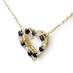 Collar con colgante de corazón abierto de oro amarillo de 14K con zafiros y diamantes